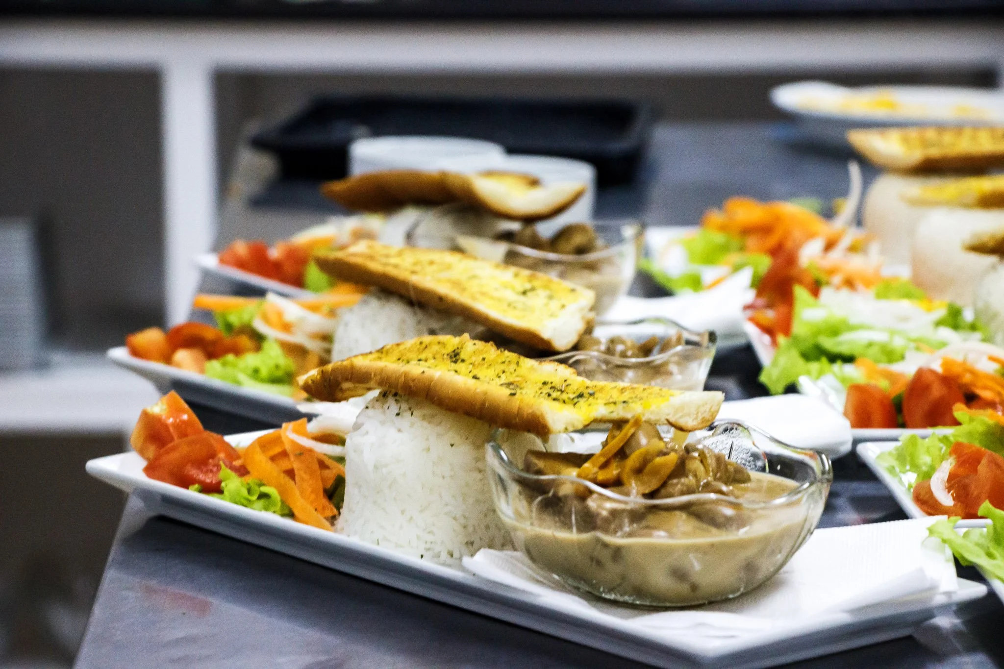 Plates of rice, grilled bread, salad, and stew