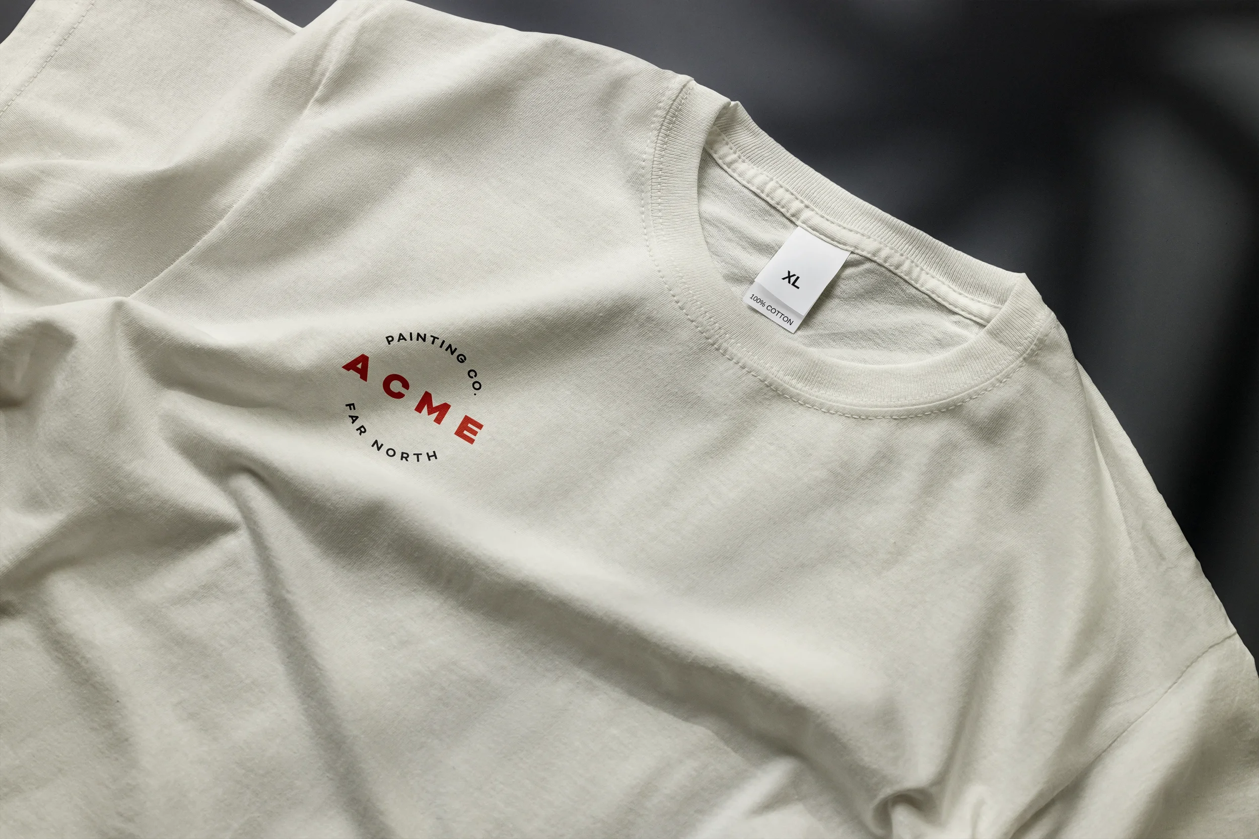 Cream-colored t-shirt with red and black text and logo for the ACME Painting Company, screenprinted on the front.