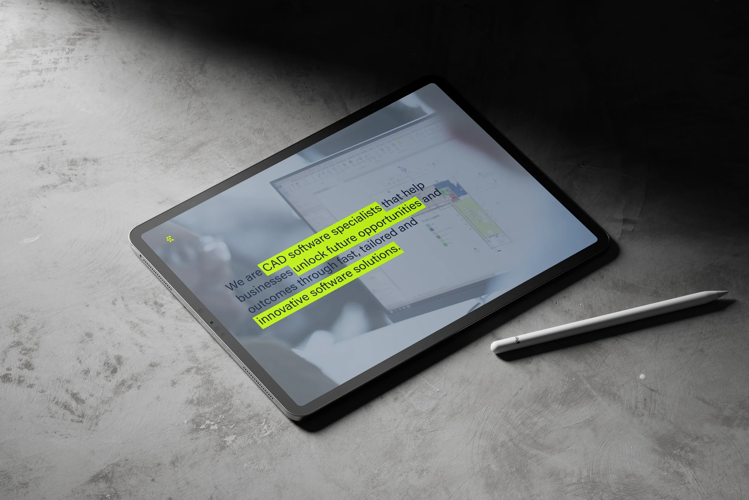 A tablet on a gray textured surface displays a presentation slide with highlighted text about CAD software specialists and innovative software solutions. A white pen is placed next to the tablet.
