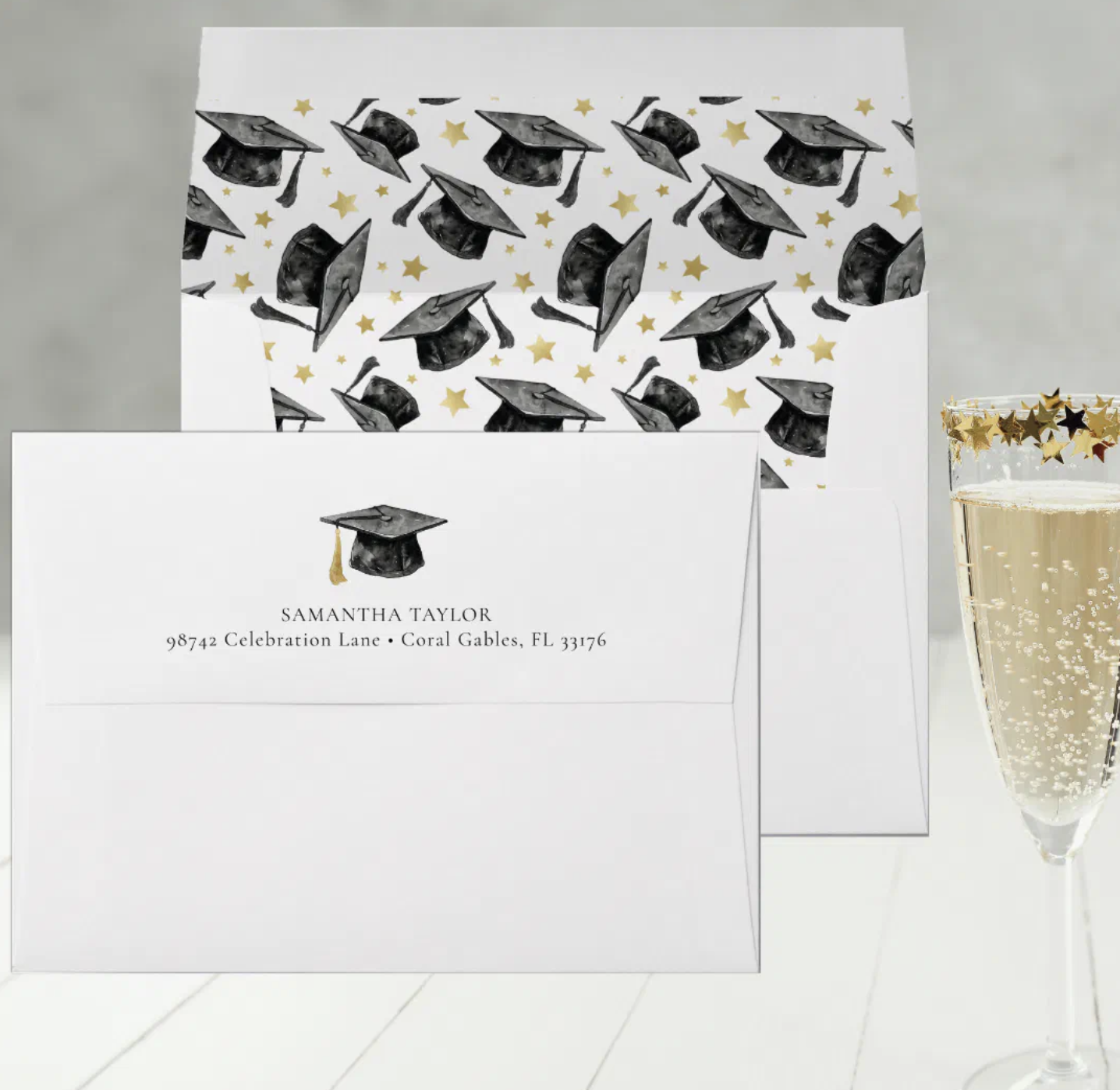 Black and white graduation envelope with gold star patterned liner and champagne glass