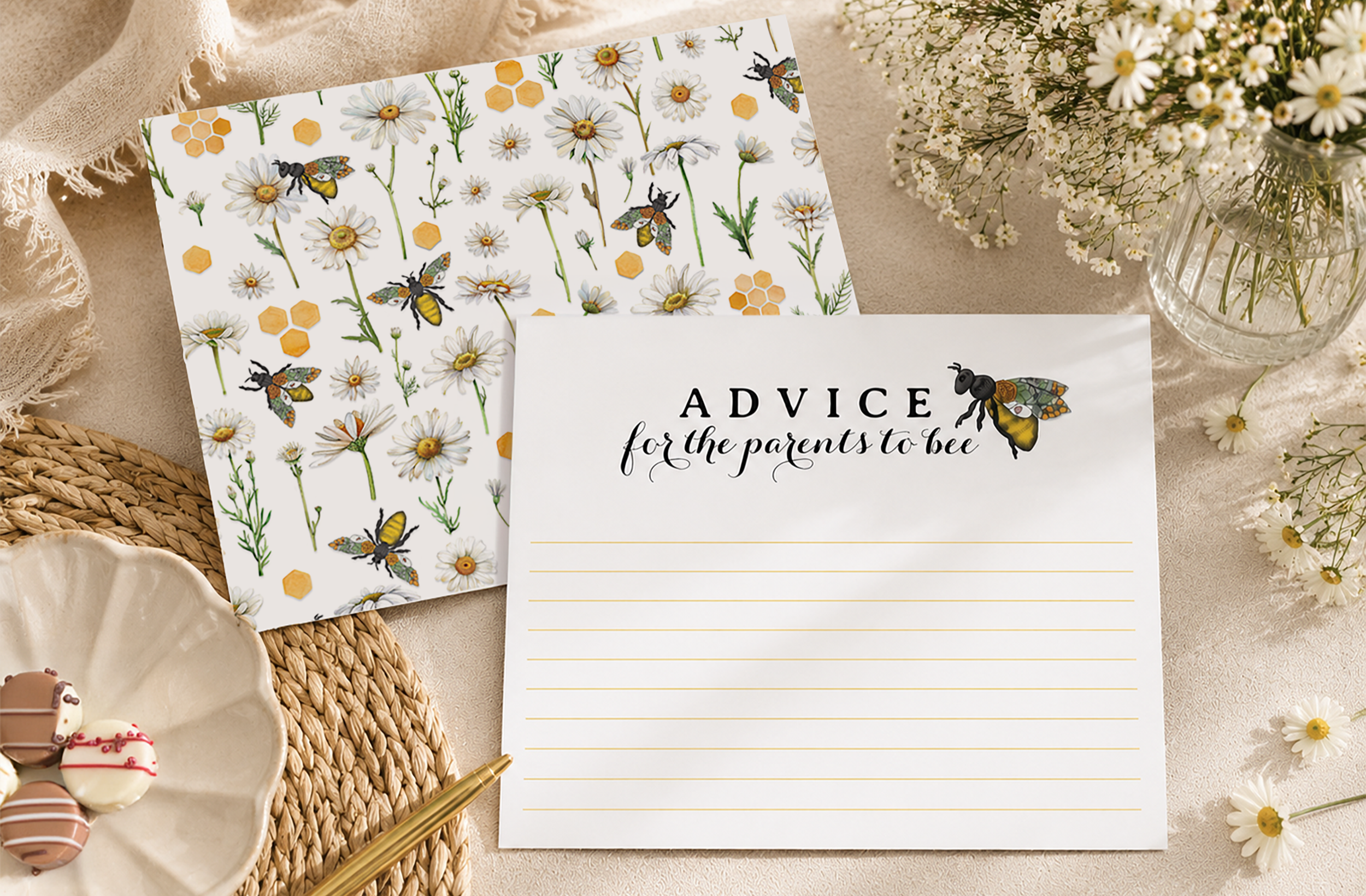 Honey bee baby shower advice card with coordinating patterned back styled in an editorial flat lay with baby's breath, a gold pen, and sweet treats.