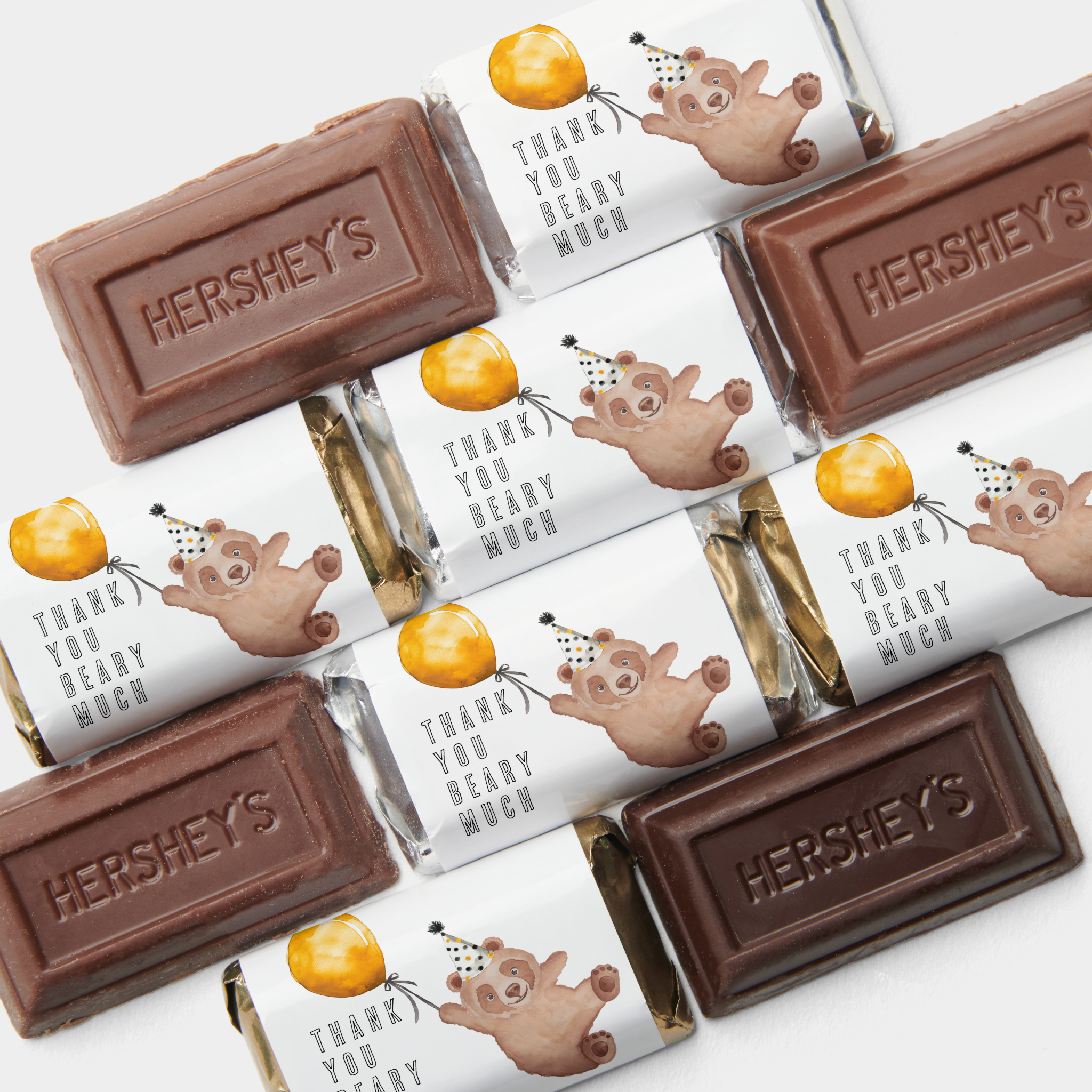 Teddy bear first birthday chocolate bar favors wrapped with “Thank You Beary Much” labels featuring watercolor bear with balloon and party hat.