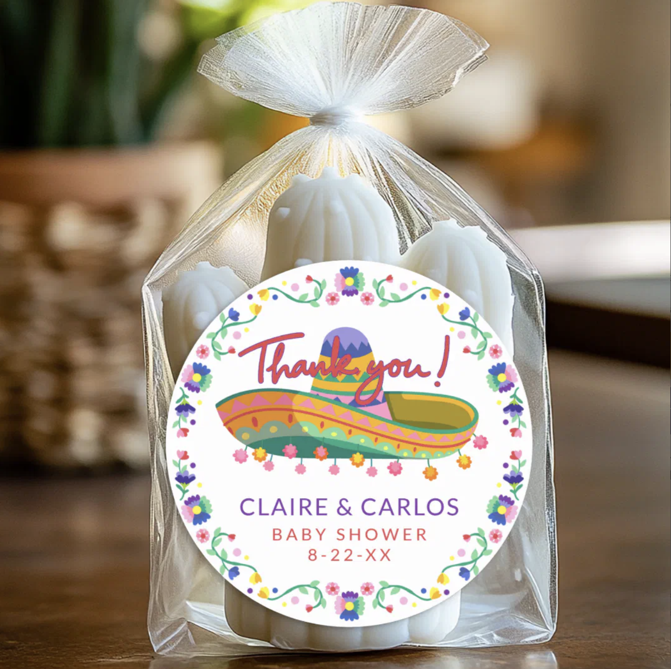 Fiesta baby shower favor with cactus-shaped soap wrapped in a clear bag and sealed with a colorful sombrero thank you sticker featuring floral details and personalized text.
