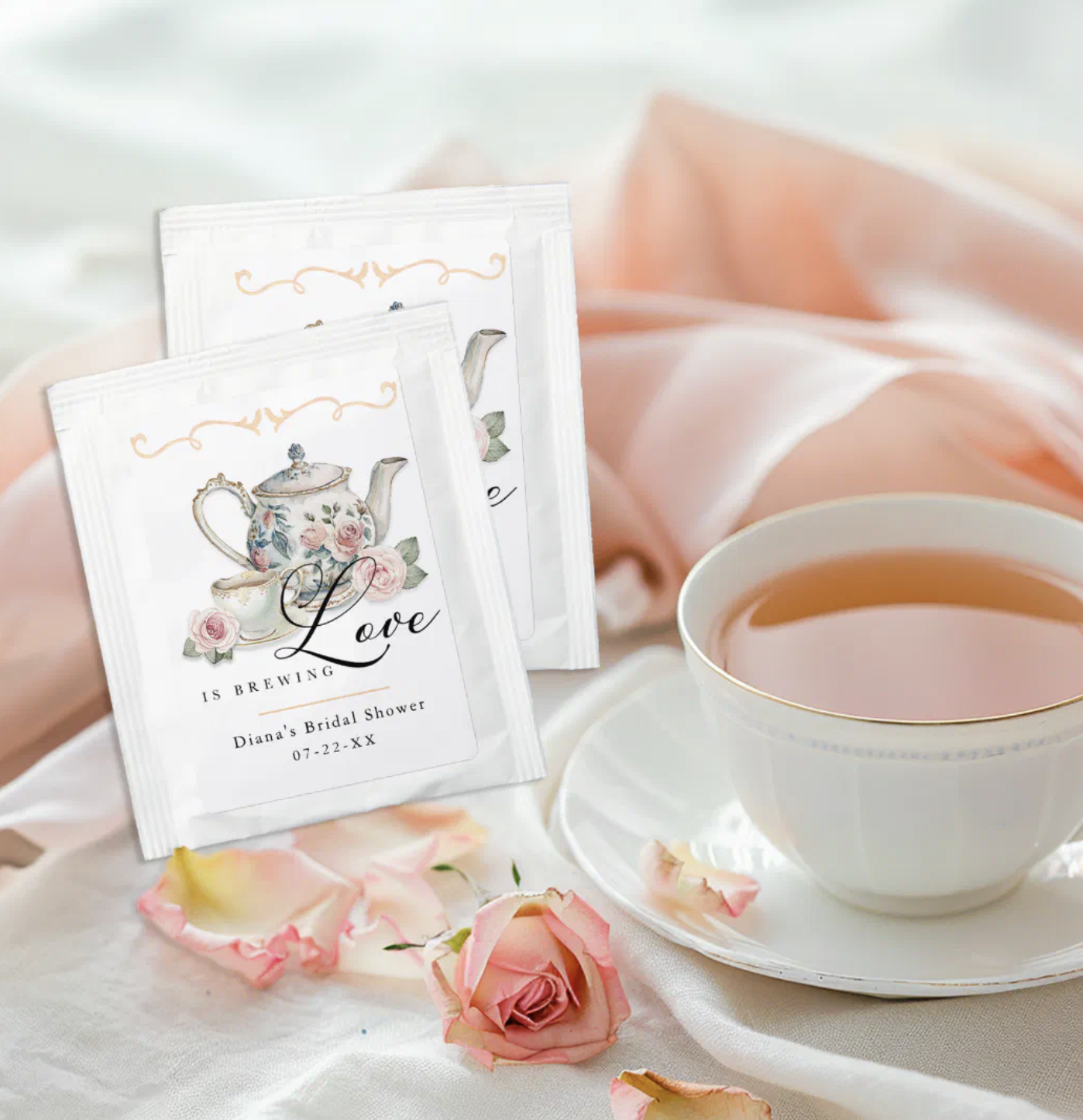 Love is Brewing tea favor packets styled beside a teacup for bridal shower favors