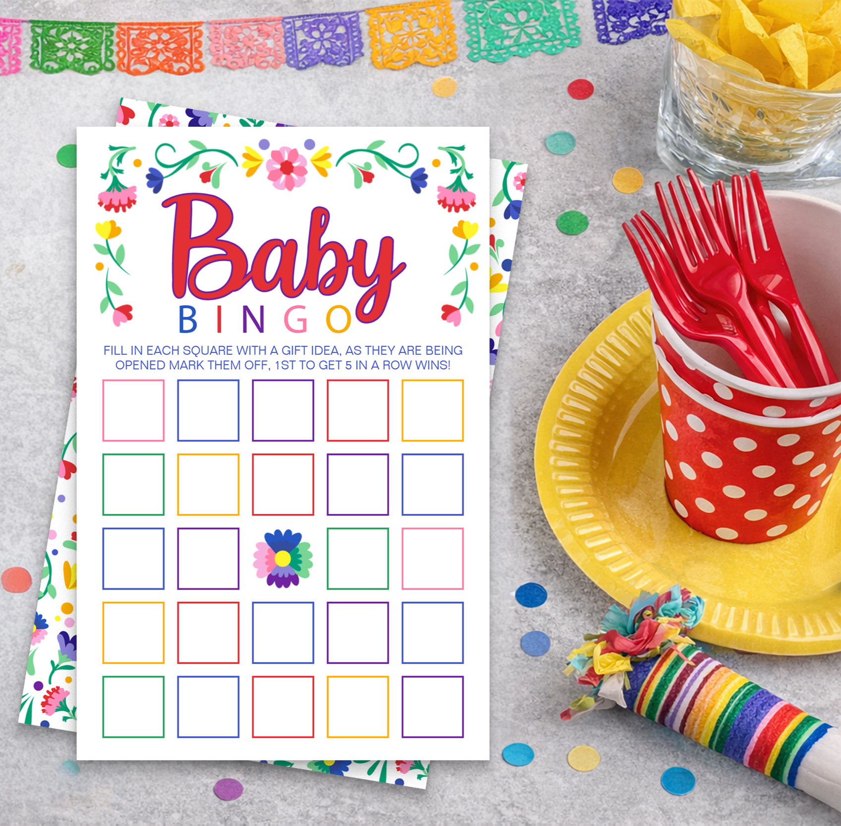 Fiesta baby shower Baby Bingo game card with colorful floral border, bright multi-colored bingo grid, and festive table setting with confetti, serape fabric, and party decorations.