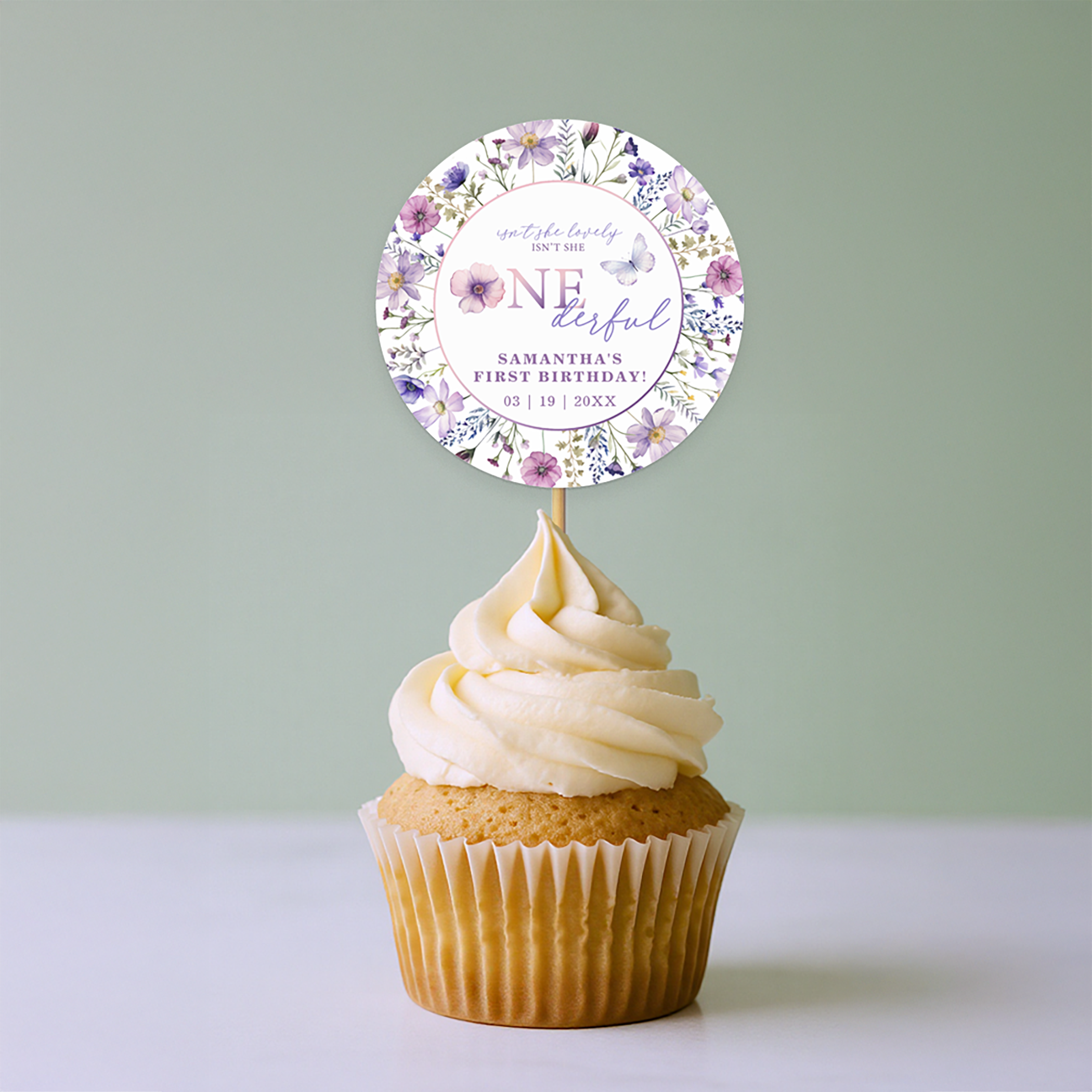 Wildflower ONEderful first birthday cupcake topper with purple floral accents, displayed on a frosted cupcake with sprinkles.