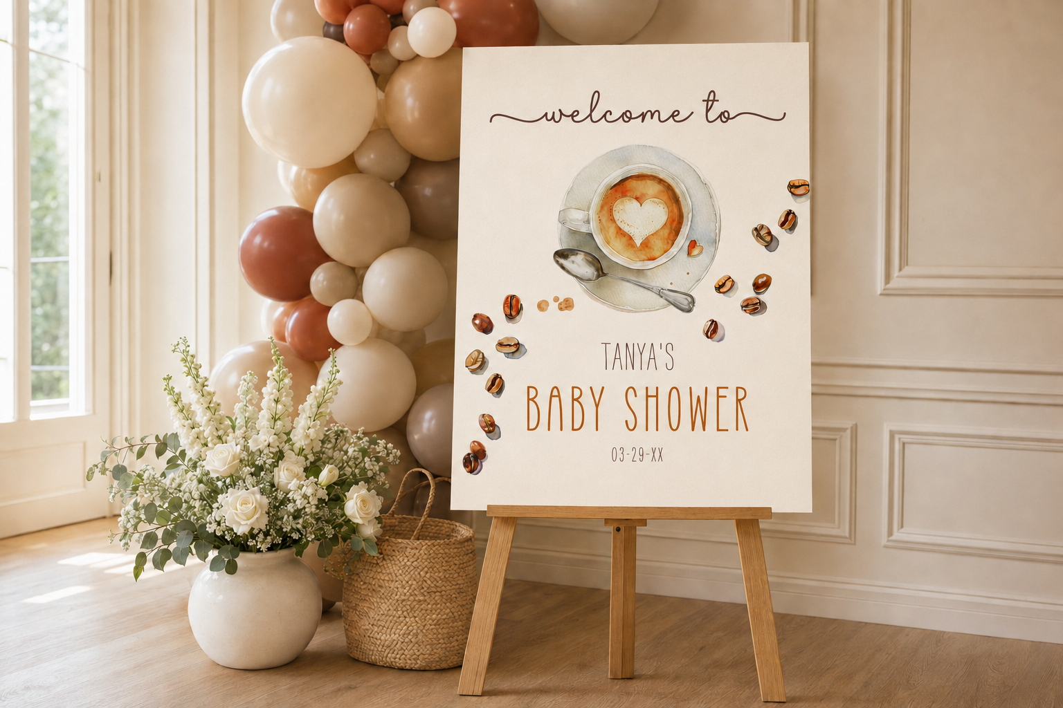 Coffee-themed baby shower welcome sign with neutral balloons, white flowers, and a wooden easel.
