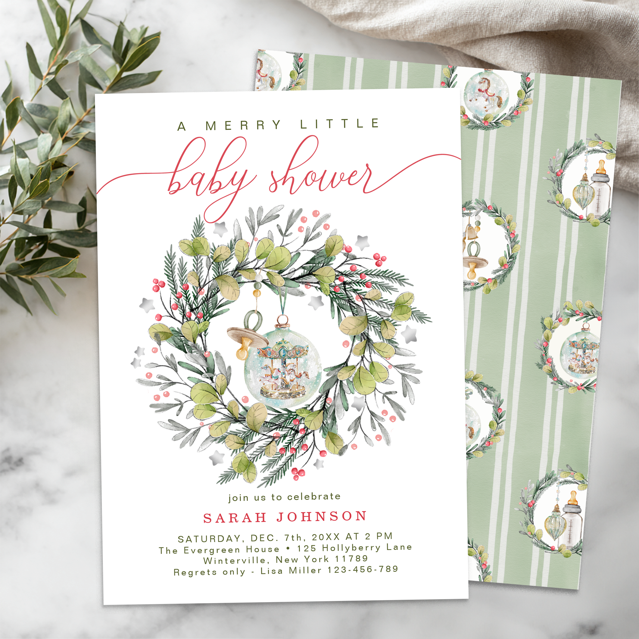 Elegant Christmas baby shower invitation with watercolor greenery wreath and vintage ornaments on soft sage striped background.