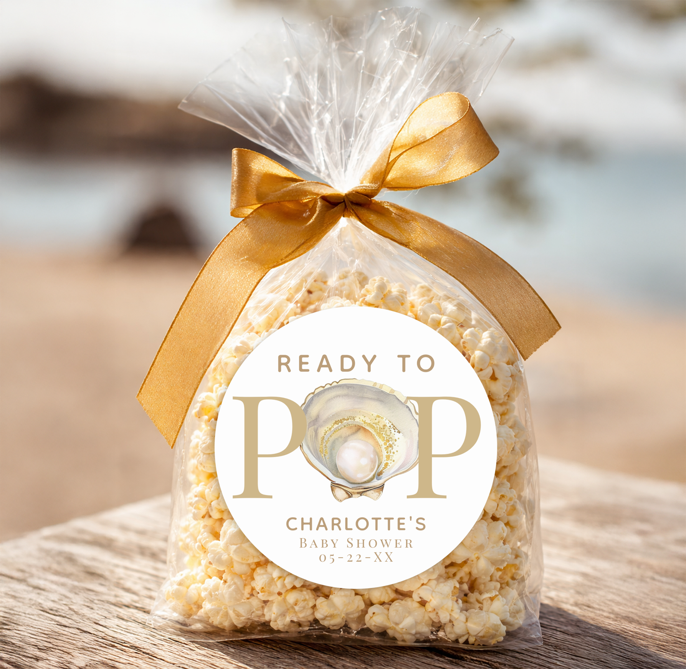 Little Pearl baby shower “Ready to Pop” popcorn favor bag with gold ribbon and oyster shell pearl sticker for a coastal baby shower