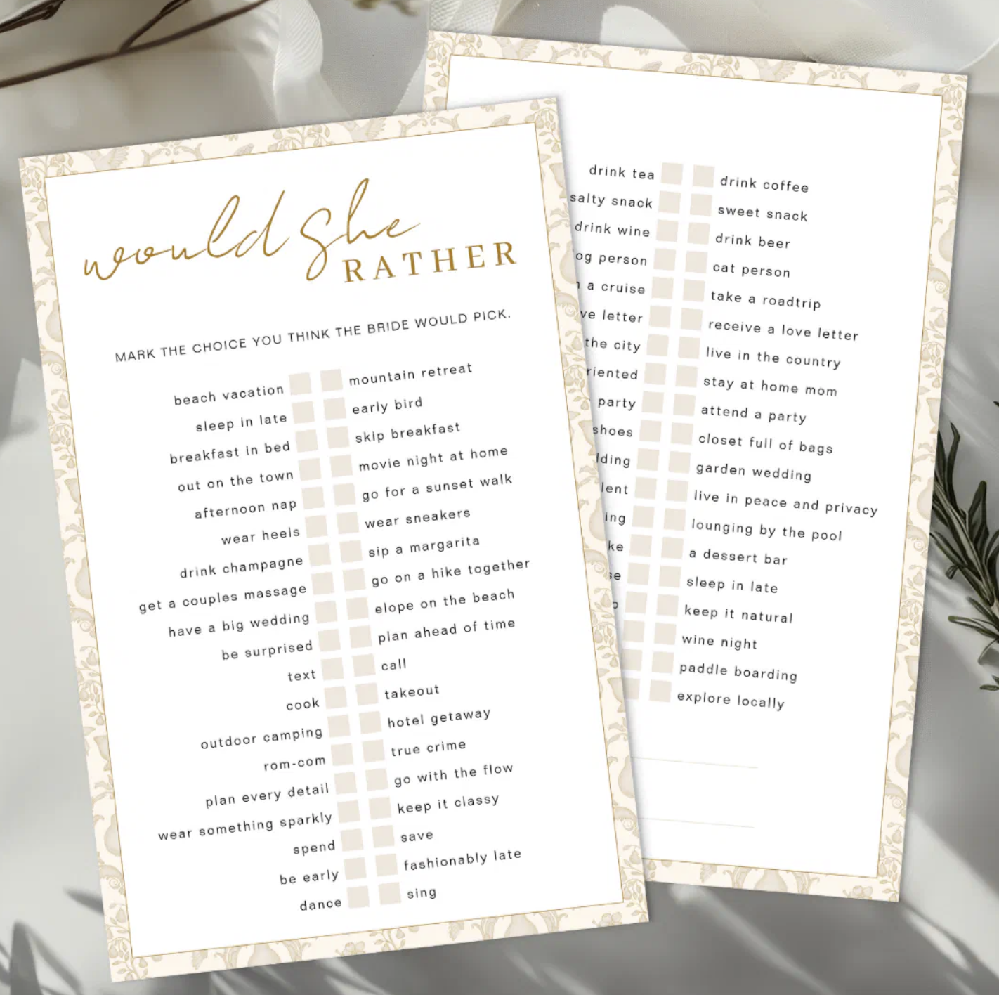 Elegant Would She Rather bridal shower game cards displayed on a soft neutral background with botanical shadows and greenery. Printable bridal shower guessing game featuring multiple choice prompts in a chic gold and cream design.