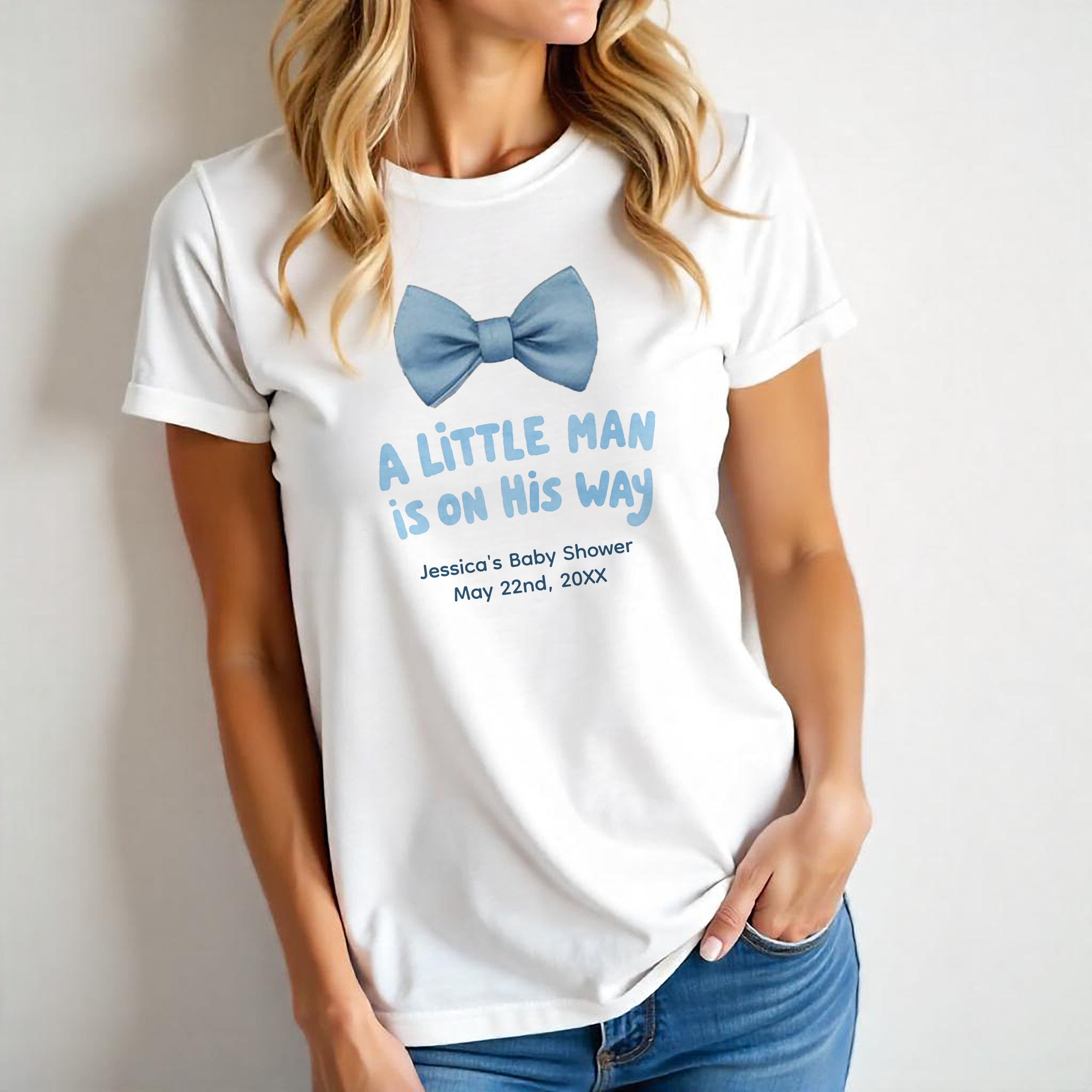 White t-shirt featuring a blue bow tie and “A Little Man Is On His Way” text, perfect for baby shower hosts or family.