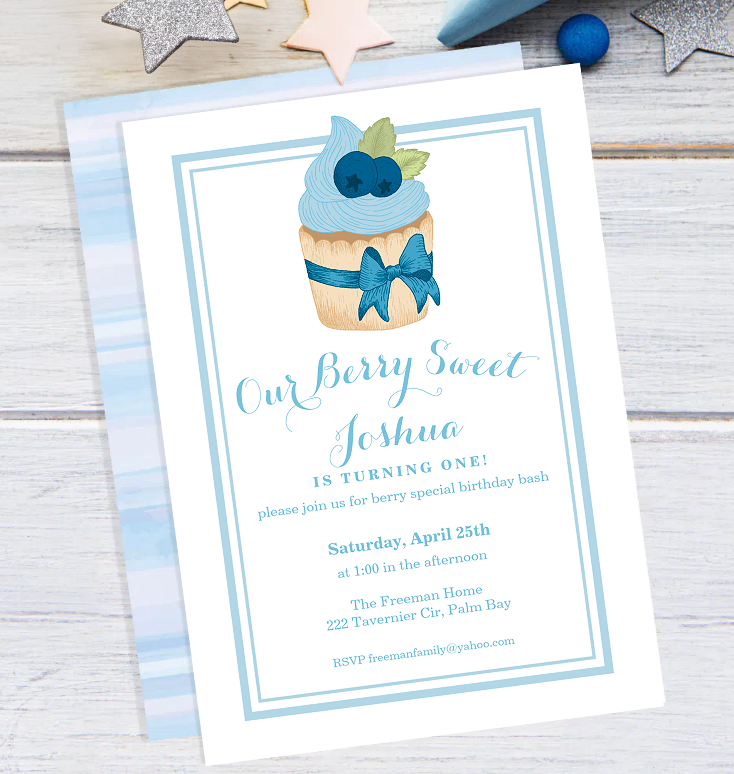 Blueberry cupcake baby boy first birthday invitation in soft watercolor blue.