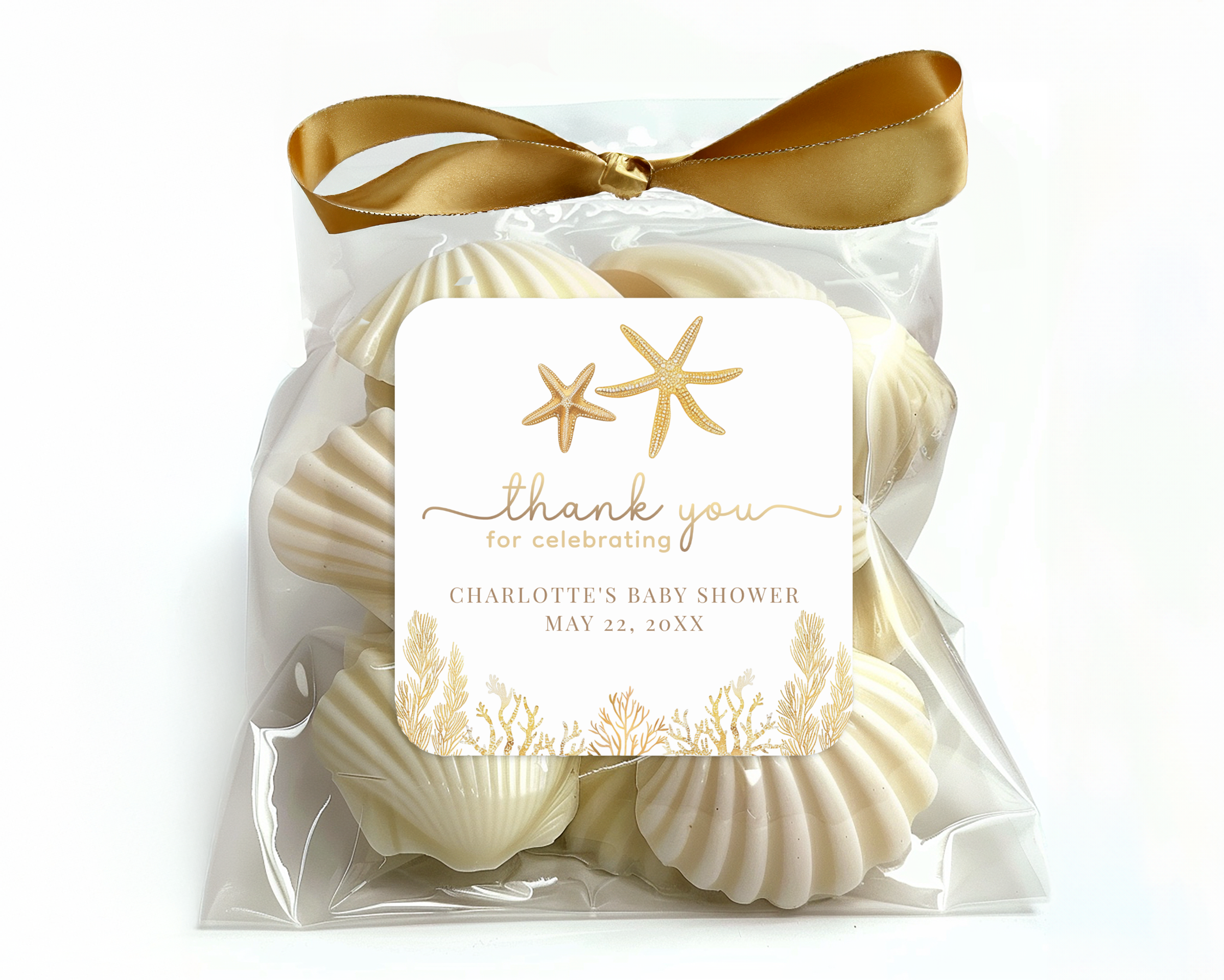 Little Pearl baby shower favor sticker with gold starfish and coastal coral details displayed on a seashell favor gift bag
