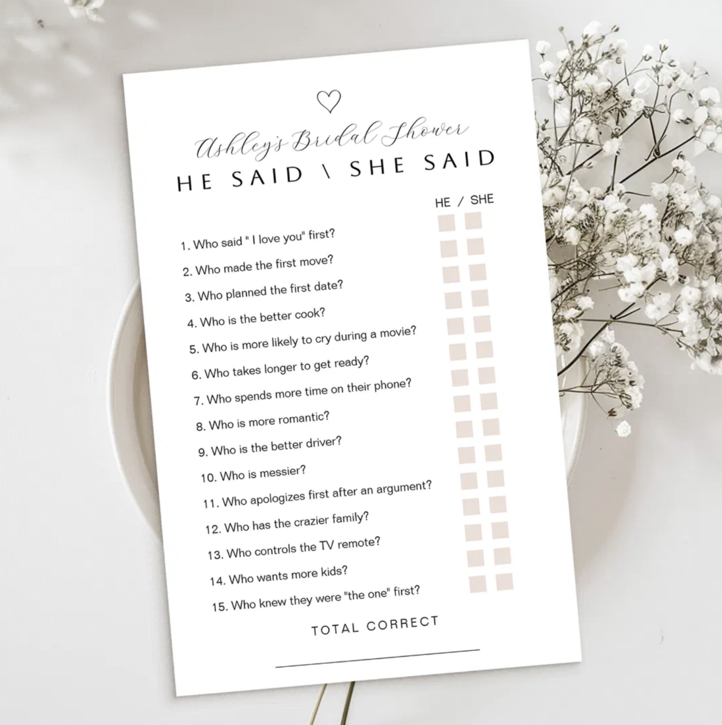 Minimalist He Said She Said bridal shower game card with blush accents and personalized heading displayed on a neutral background with delicate white baby's breath flowers. Printable bridal shower couple trivia game for guests.