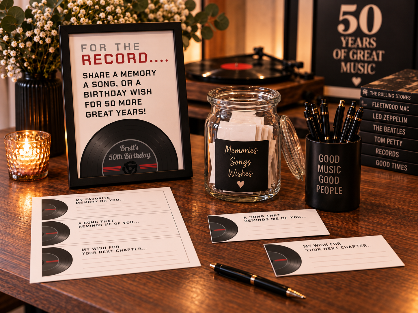 50th birthday memory station with a framed “For the Record” sign, printable cut-apart memory cards, pens, a keepsake jar, candlelight, flowers, and retro vinyl record decor.