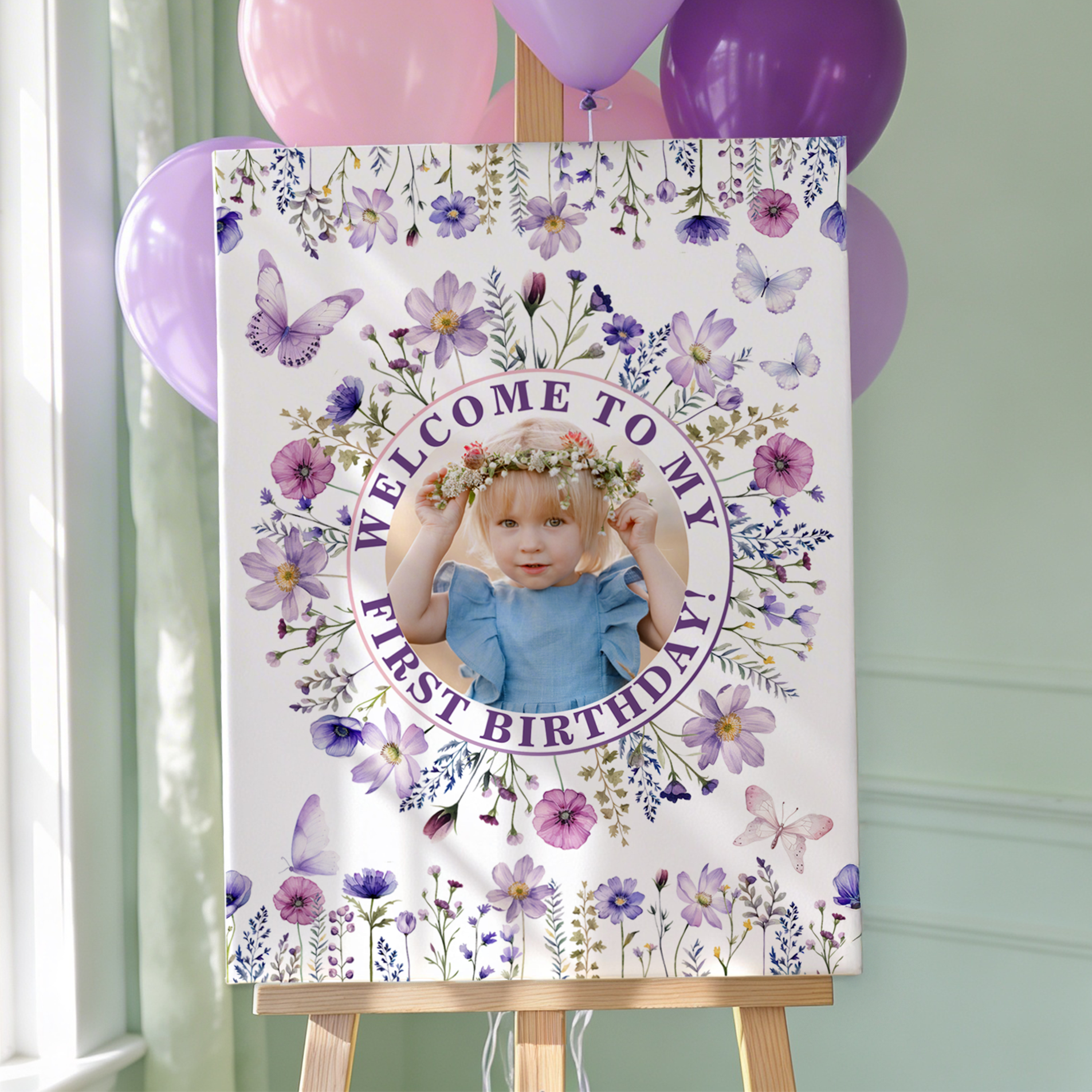 Purple wildflower ONEderful first birthday welcome sign with butterflies and floral details, styled with pastel balloons.