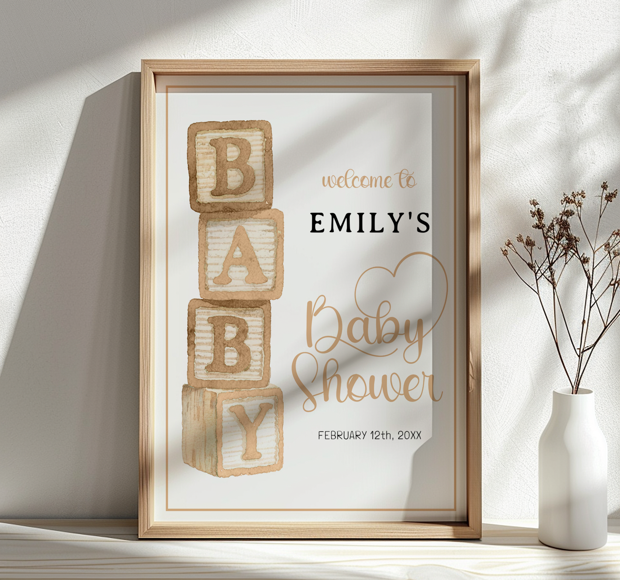 Taupe baby blocks welcome sign for baby shower displayed in a wooden frame with neutral decor.