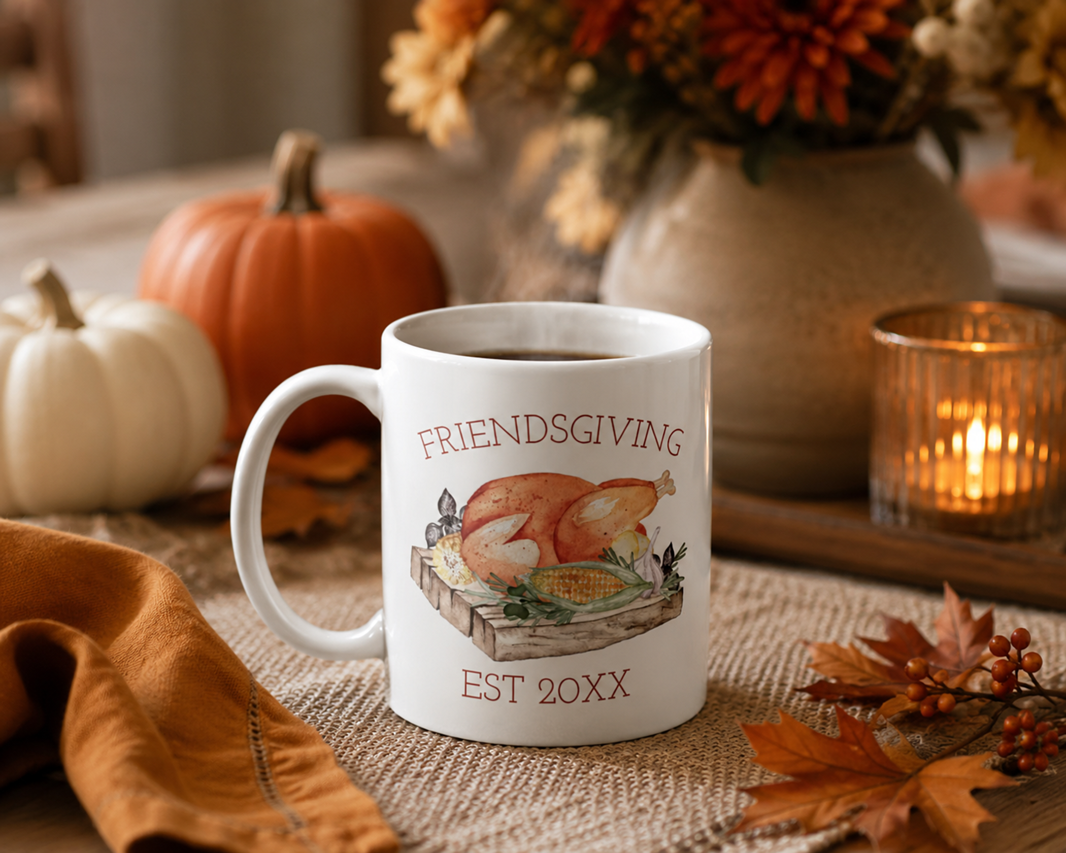 White Friendsgiving ceramic mug featuring watercolor turkey artwork styled in a cozy autumn setting with pumpkins, candlelight, fall leaves, and warm seasonal décor.