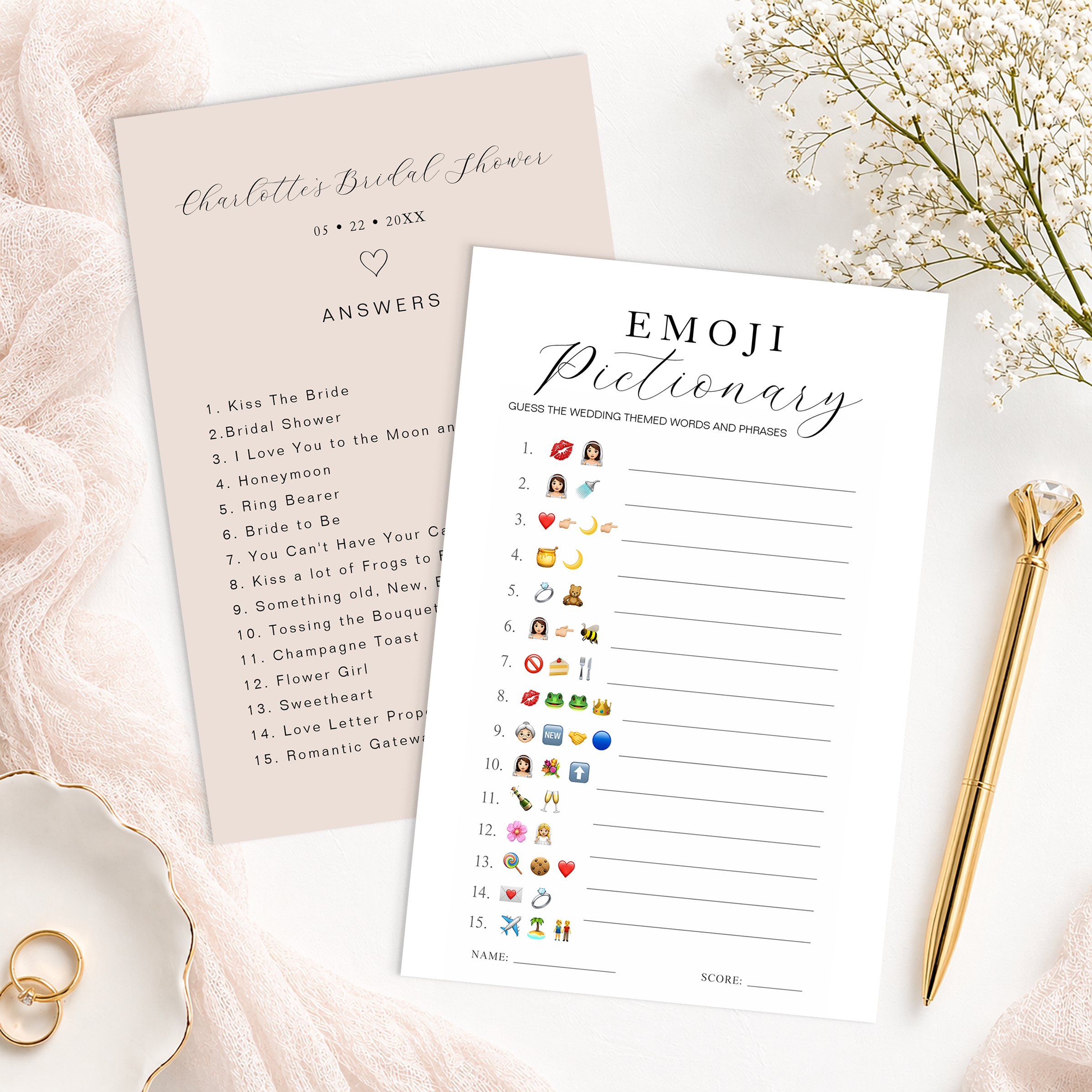 Elegant bridal shower emoji pictionary game card with matching answer sheet, gold pen, rings, and blush fabric styling on a white background. Printable wedding-themed bridal shower game featuring emoji clues and modern script design.