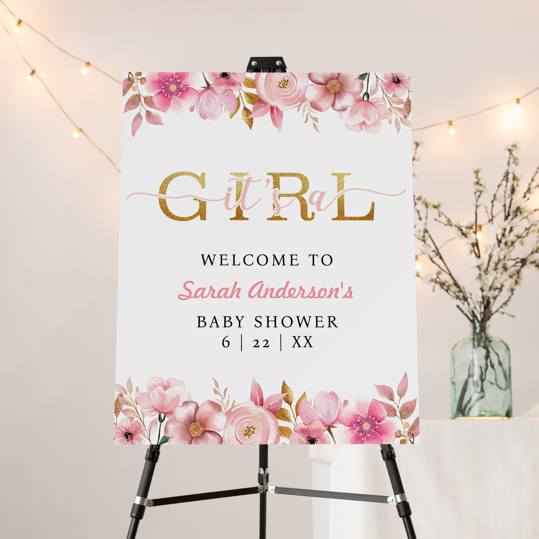 Blush pink floral baby shower welcome sign with gold lettering and watercolor flowers on an easel