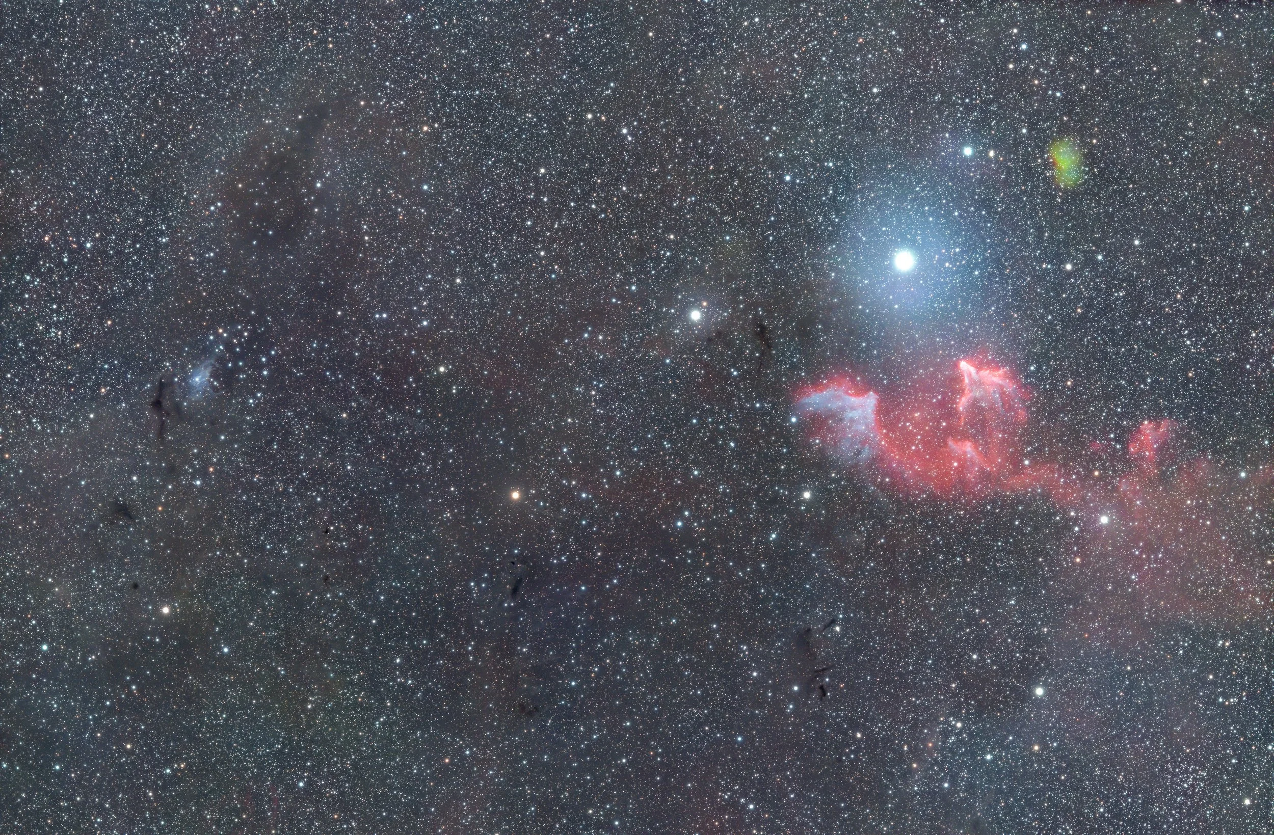A vast starry night sky filled with numerous stars, nebulae, and cosmic dust, with a bright star and colorful nebulae visible on the right side.