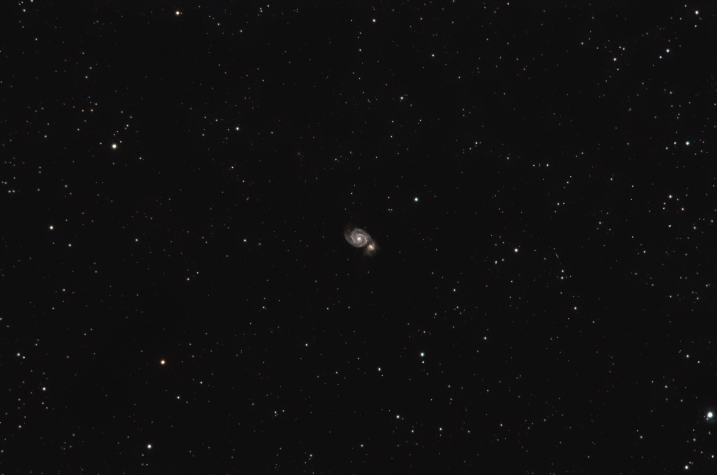 A starry night sky with numerous stars and a spiral galaxy near the bottom center of the image.