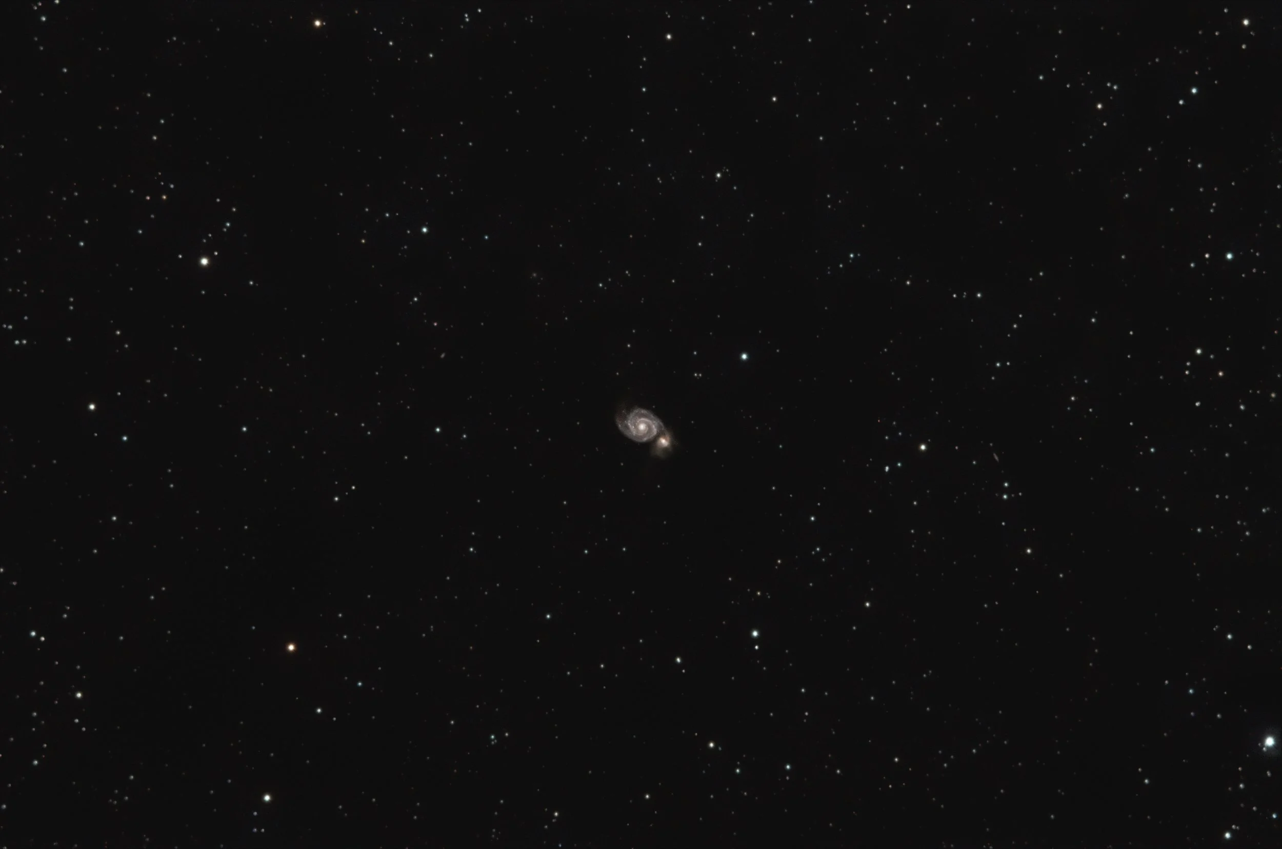 A star-filled night sky with a visible spiral galaxy near the bottom center of the image.