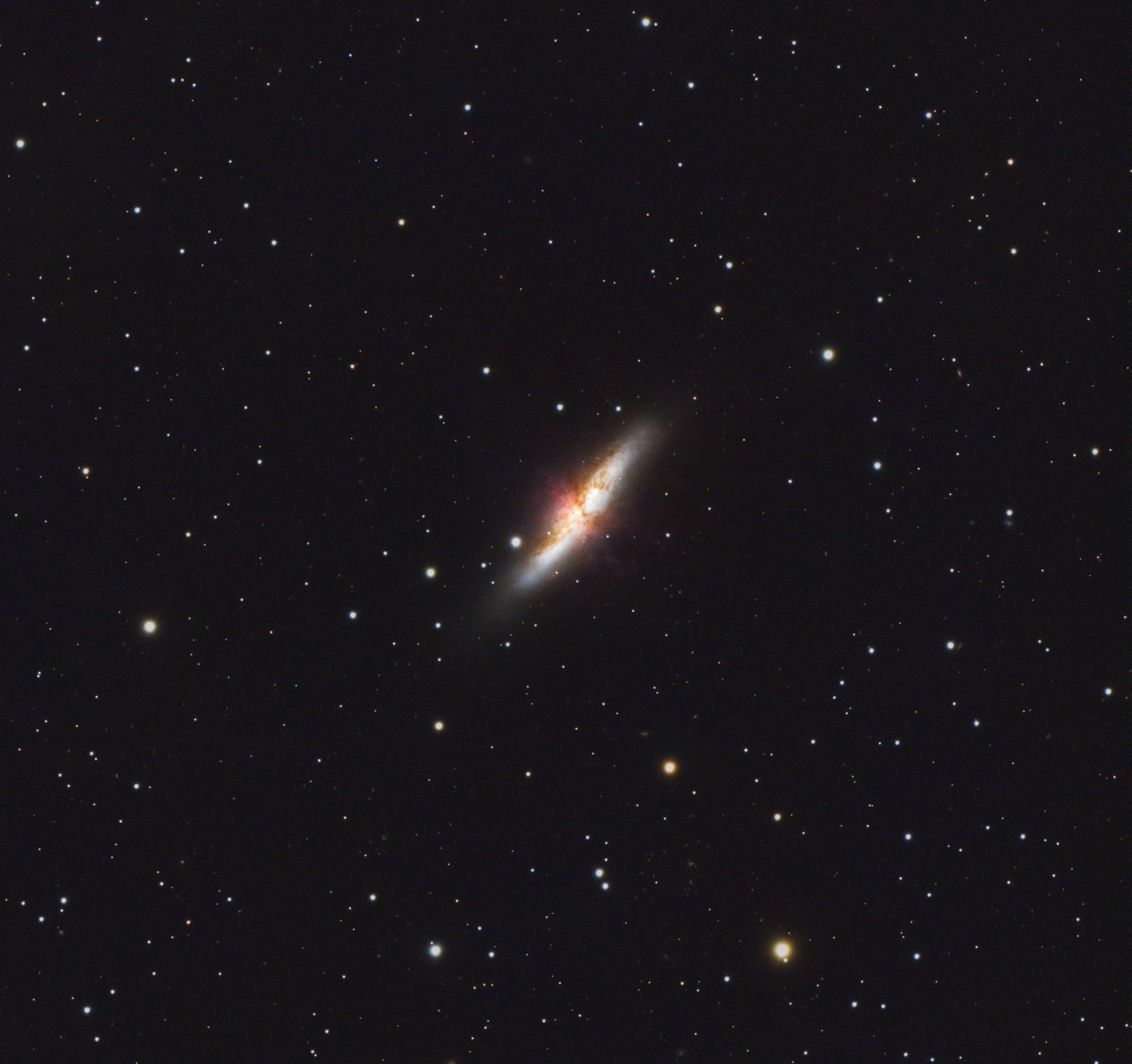A clear night sky filled with numerous stars and a bright, elongated galaxy near the bottom center of the image.