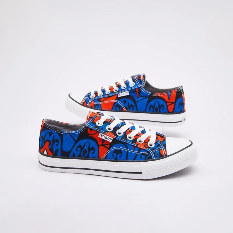 Pair of low-top sneakers with a colorful abstract pattern in blue, red, and black, white laces, and a white rubber sole, against a white background.