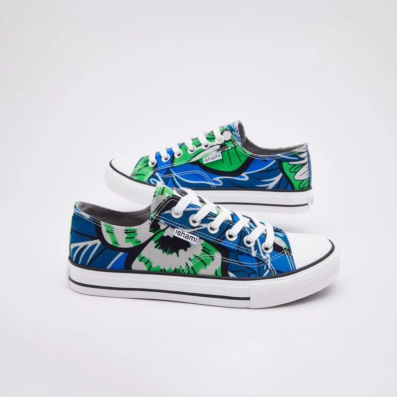 Pair of colorful sneakers with green, blue, black, and white abstract floral patterns, white laces, and soles, placed on a white surface.