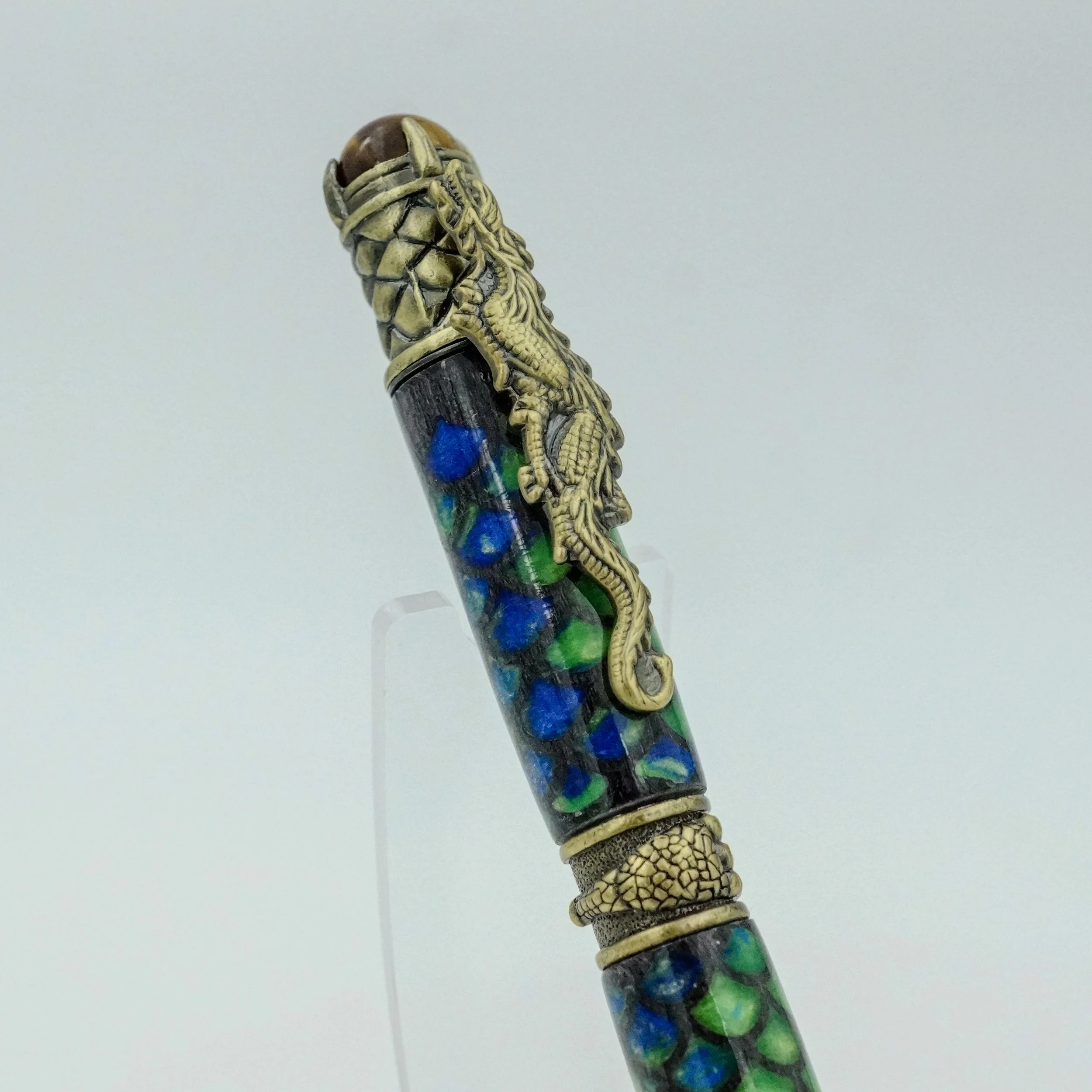 Decorative pen with gold and black snake and dragon designs and an ornate cap.