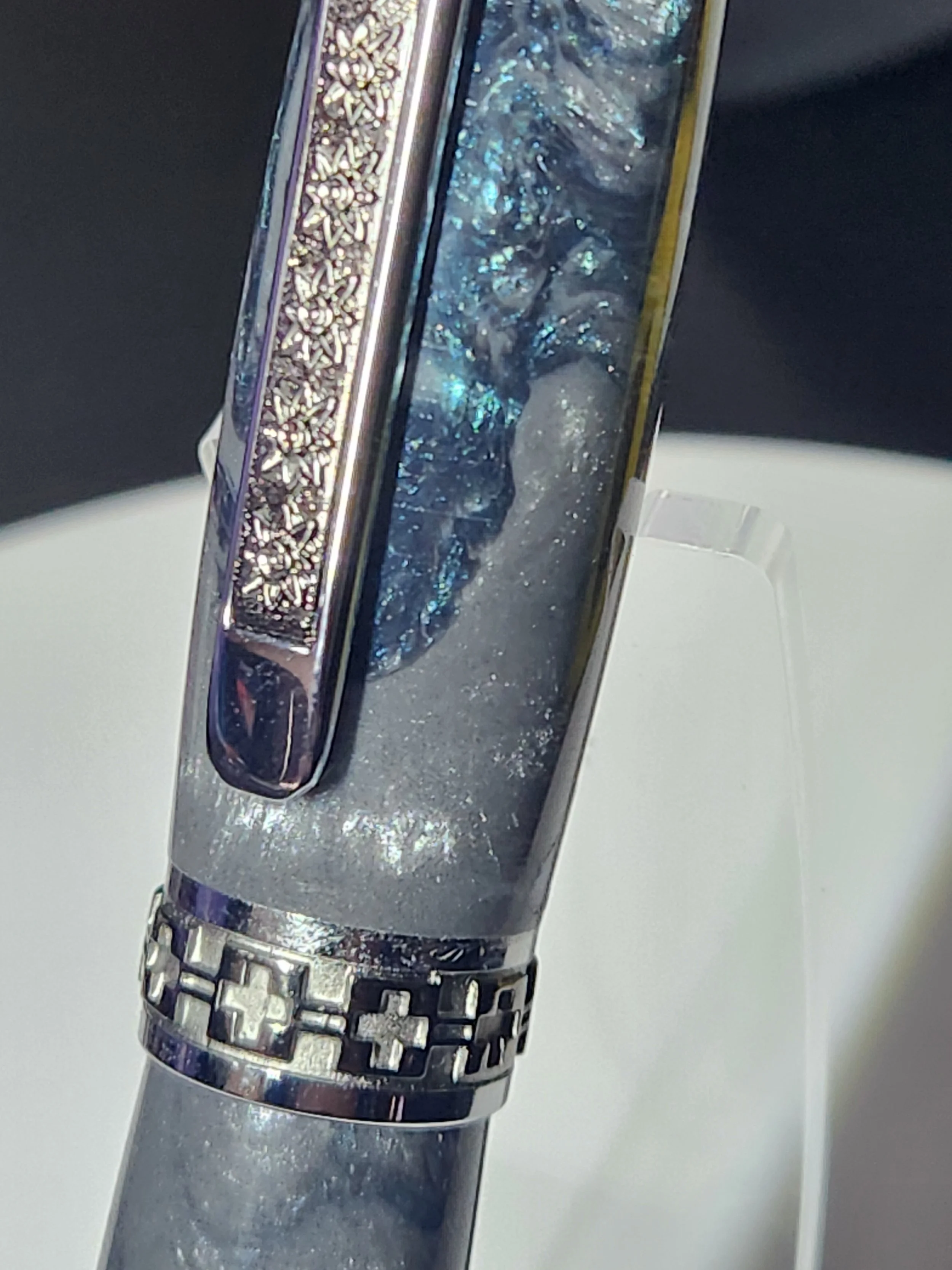 Close-up of a metallic object with intricate patterns and a textured surface, possibly part of a decorative tool or ornament.