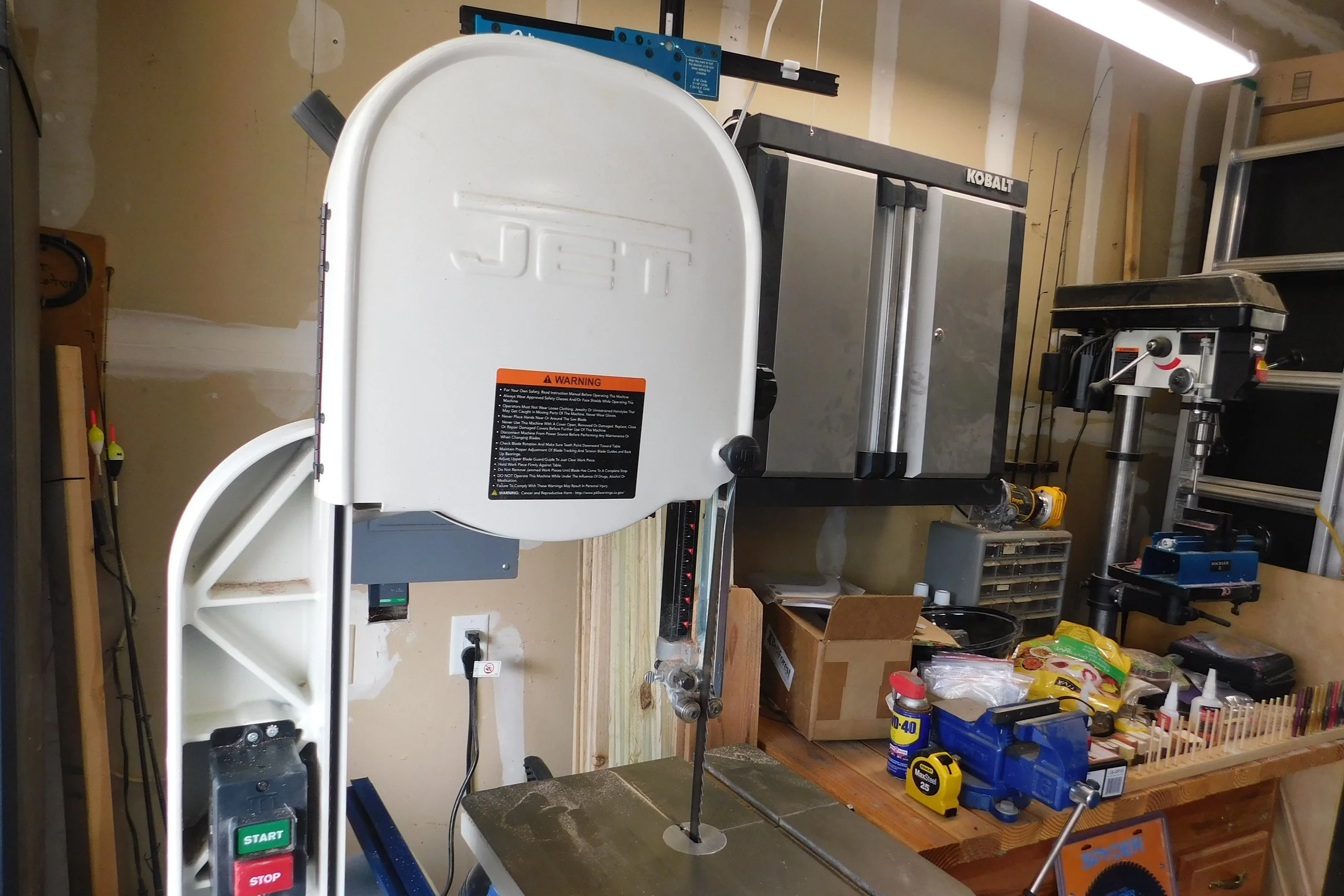 A sawzall drill in a garage workshop surrounded by various tools and supplies.