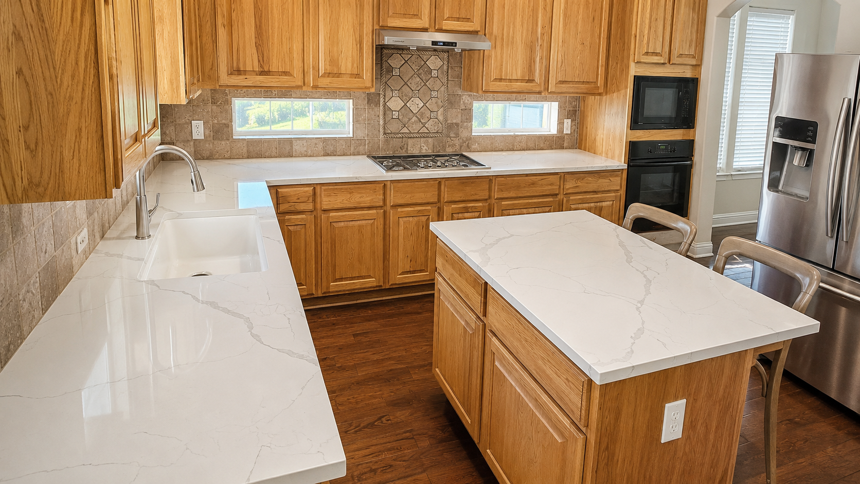 White calacatta-style quartz countertops with waterfall island and oak cabinets, kitchen remodel by Austin ProBuild in Austin, Texas