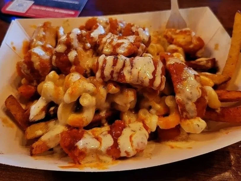 Kenny fries. cajun fries topped with white cheddar mac and cheese and chicken tossed in wing sauce drizzled in ranch