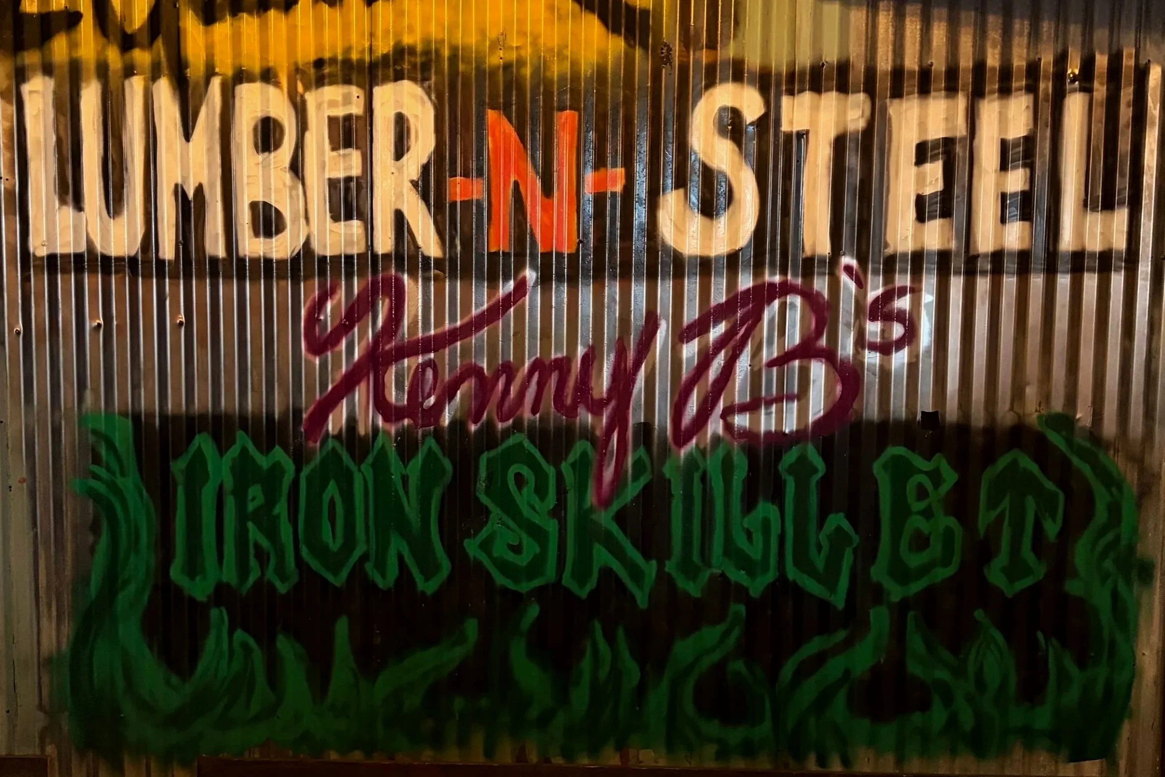Graffiti painted band names featuring "lumber n steel" and "iron skillet"