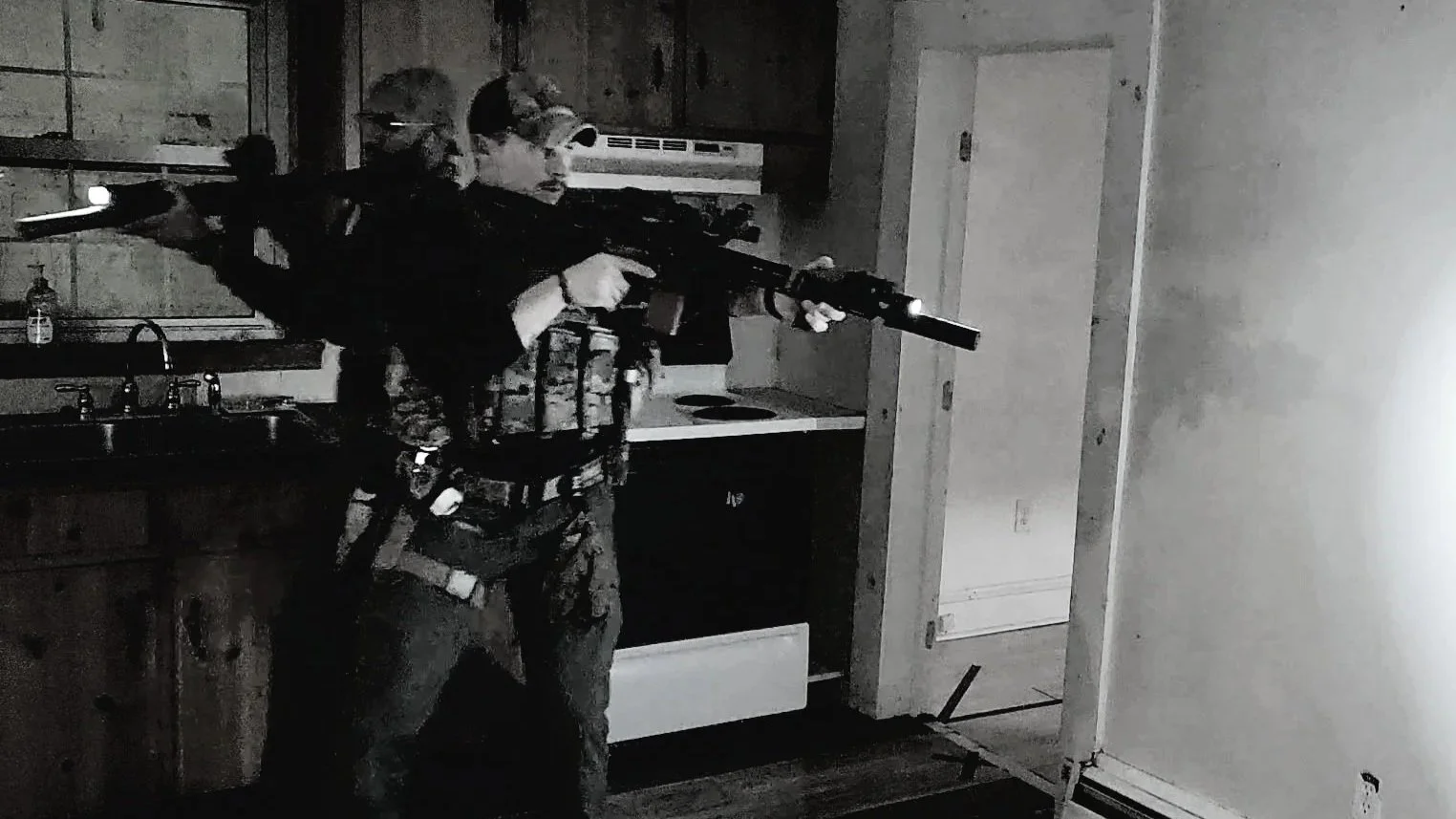 2 soldiers standing back to back with rifles in a tactical close quarter battle (CQB) environment