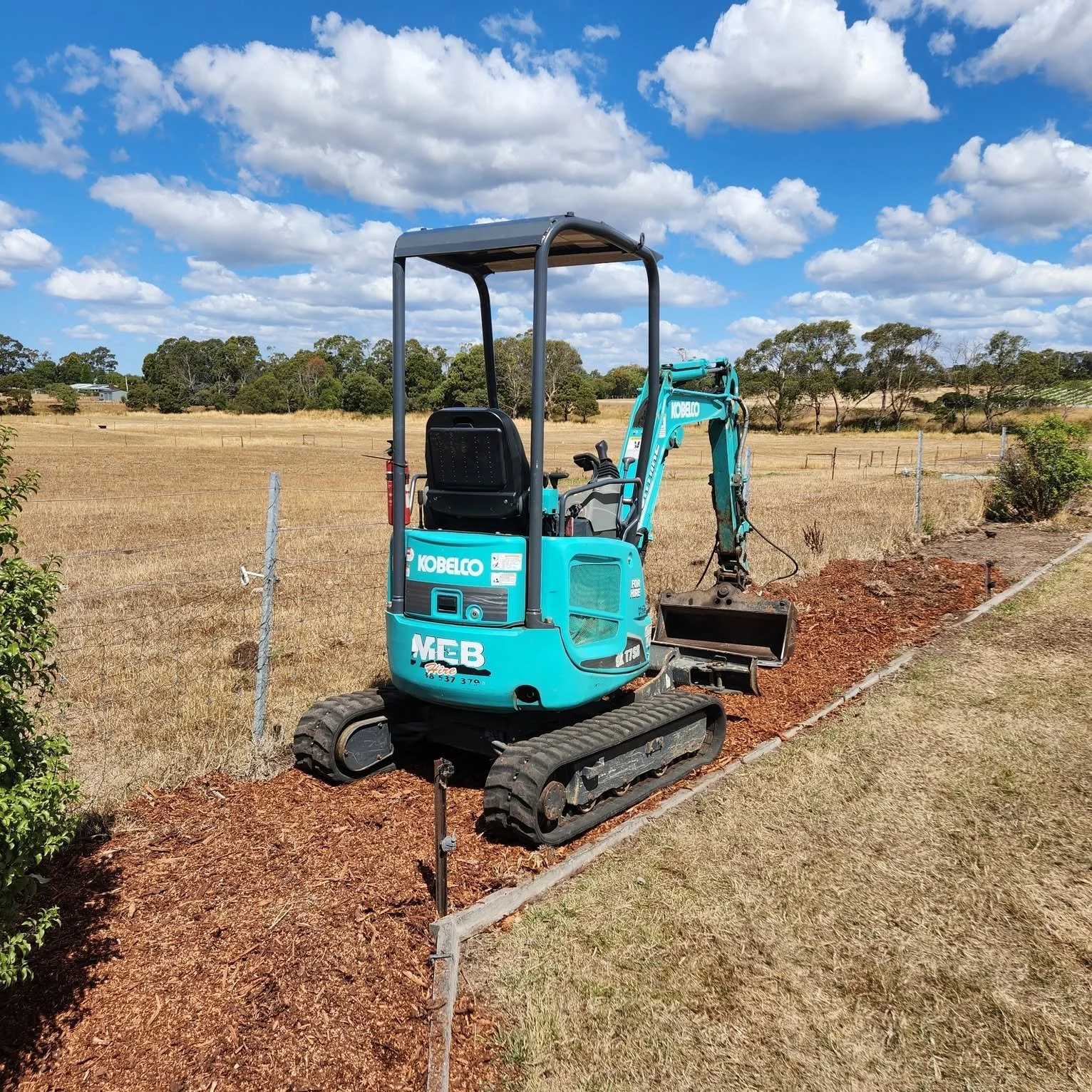 Kobelco mini excavator working in a field for dry hire