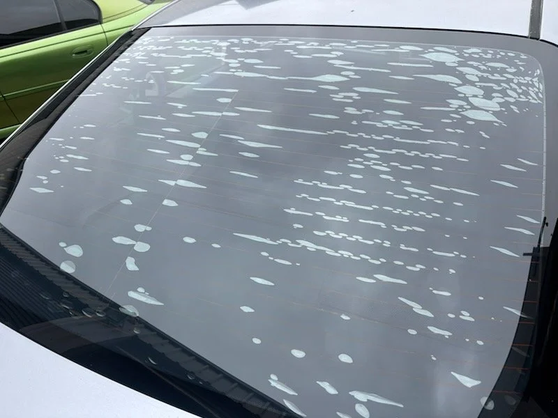 A car's rear windshield with Bubbled window tint, from sun exposure