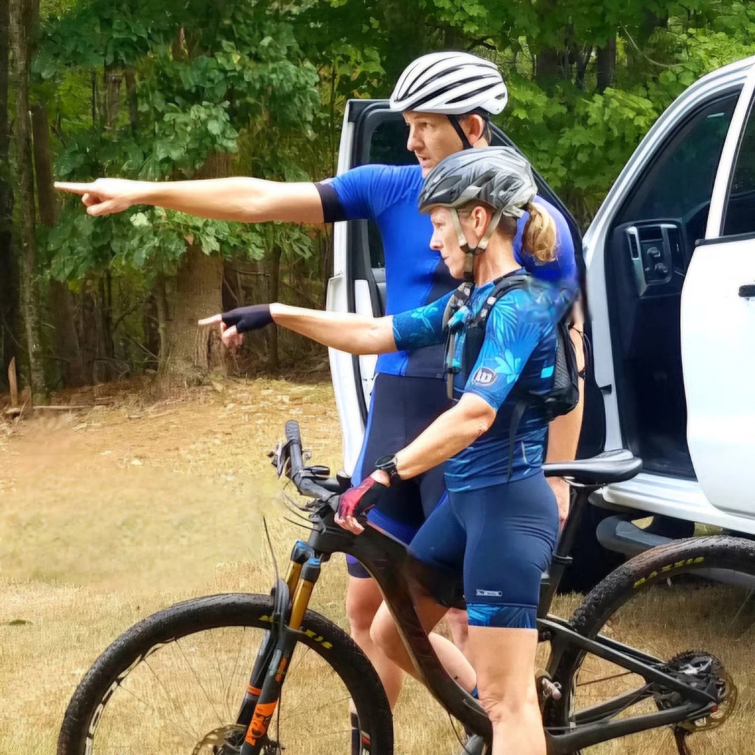 Simon and a mountain bike rider pointing into the distance.