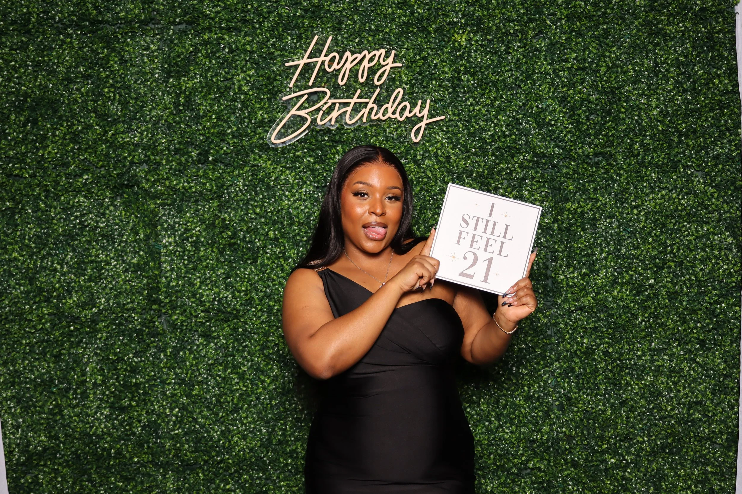 Birthday photo booth rental at Jacaranda Golf Club in Plantation, FL with green hedge wall and “Happy Birthday” sign