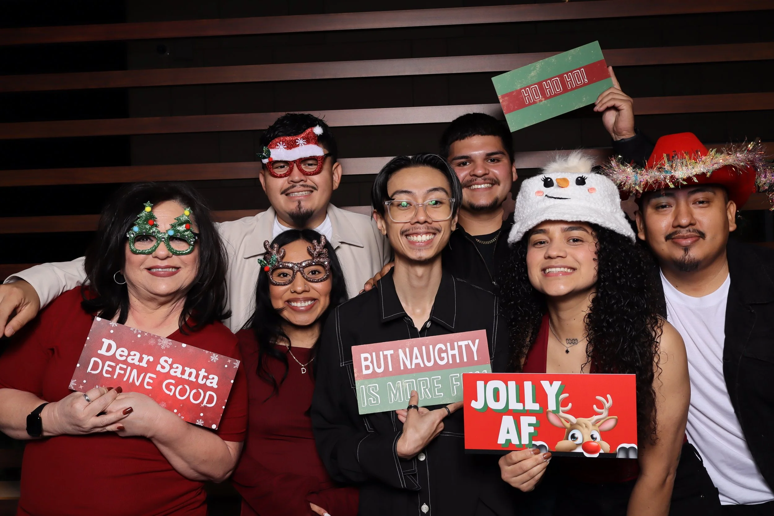 Palm Beach Gardens corporate holiday party photo booth with wooden wall and Santa and elf hats at Life Time Fitness