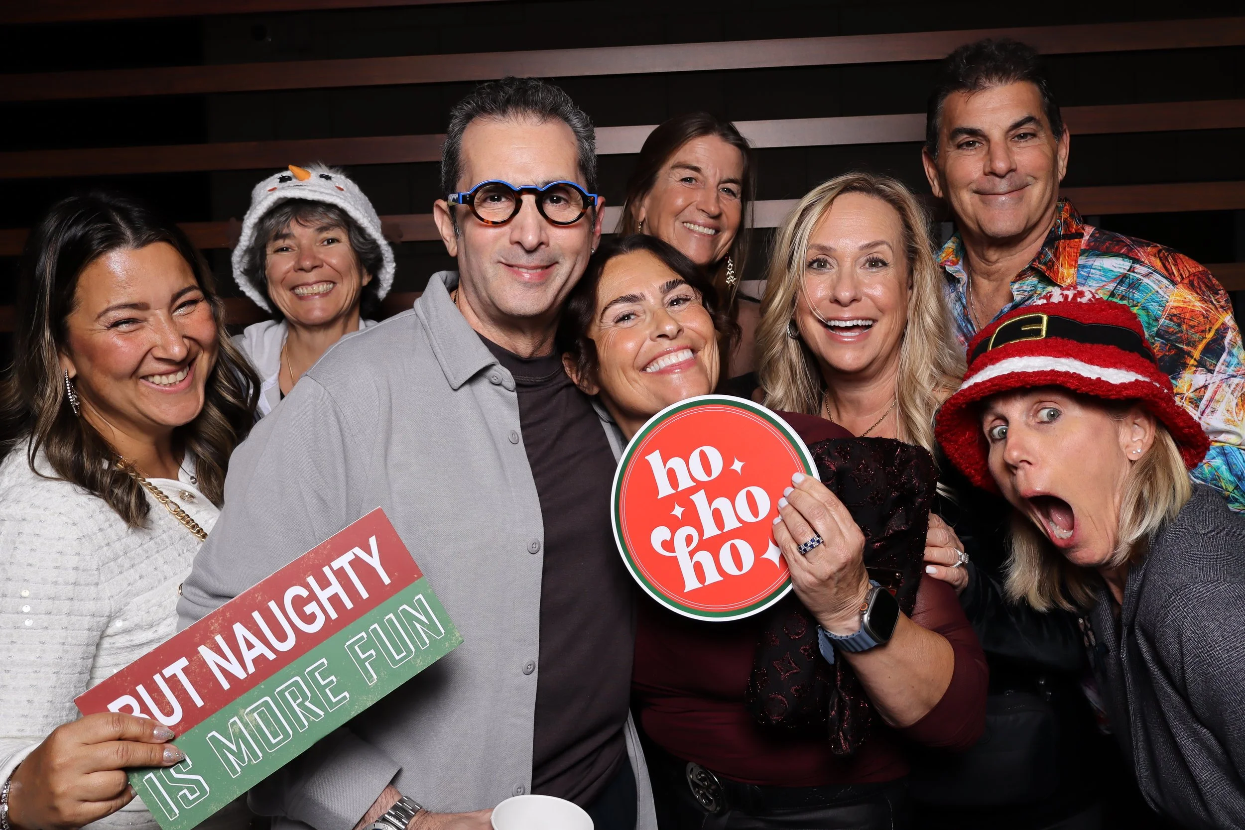 Corporate Christmas party photo booth rental at Life Time Fitness in Palm Beach Gardens with wooden wall and holiday accessories