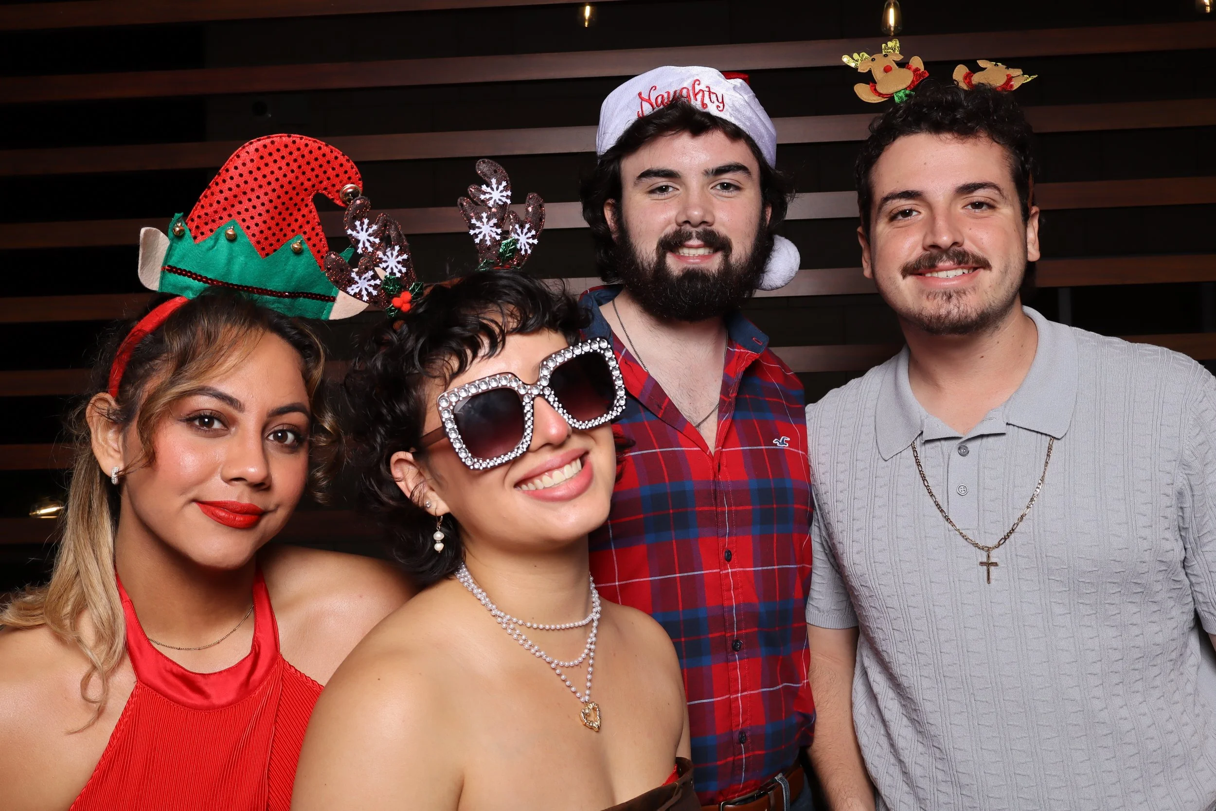 Palm Beach Gardens corporate holiday party photo booth with wooden wall and Santa and elf hats at Life Time Fitness