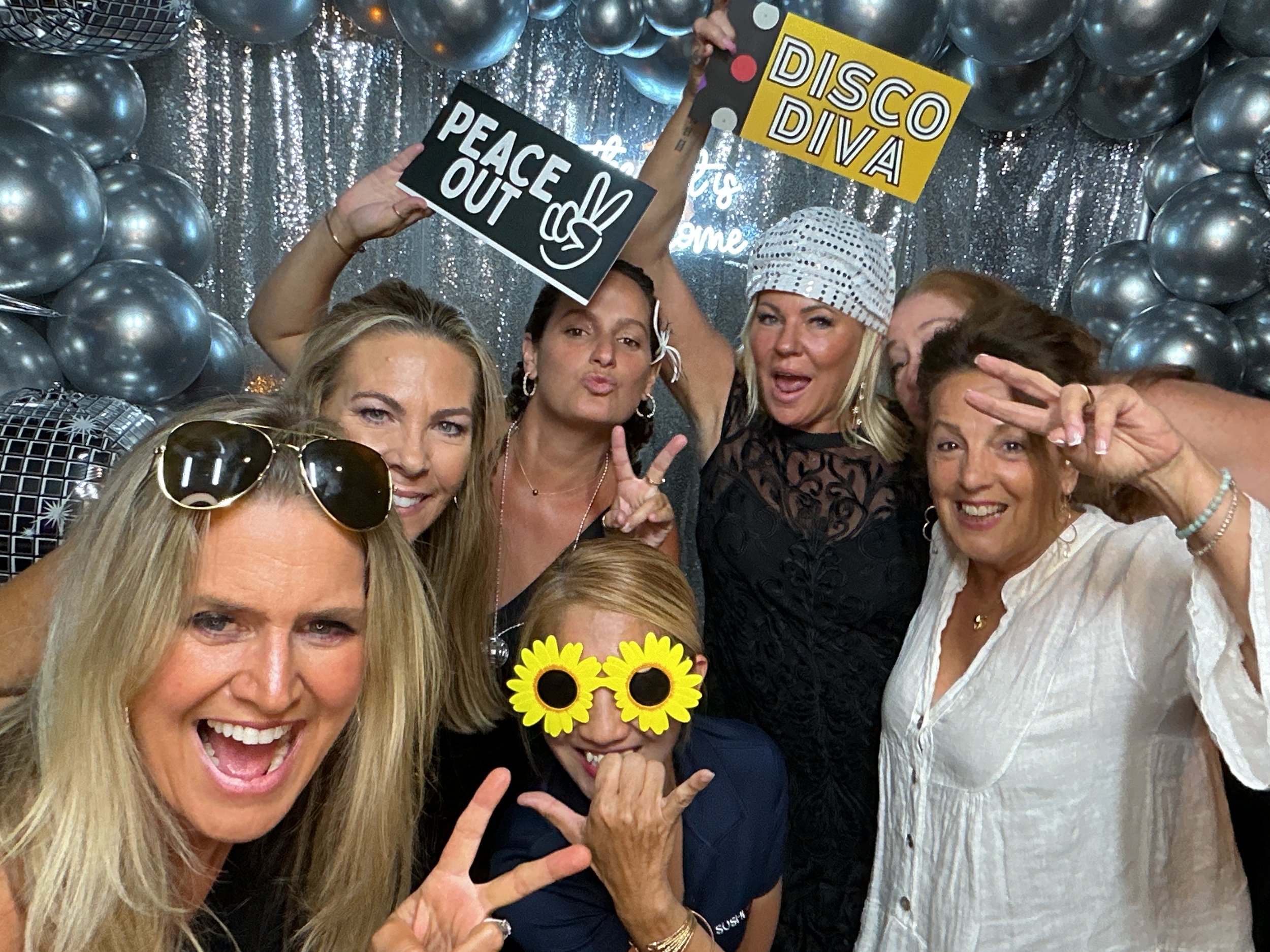 Graduation party photo booth rental at Sushi Jo's in West Palm Beach with silver sequin backdrop and disco-themed props