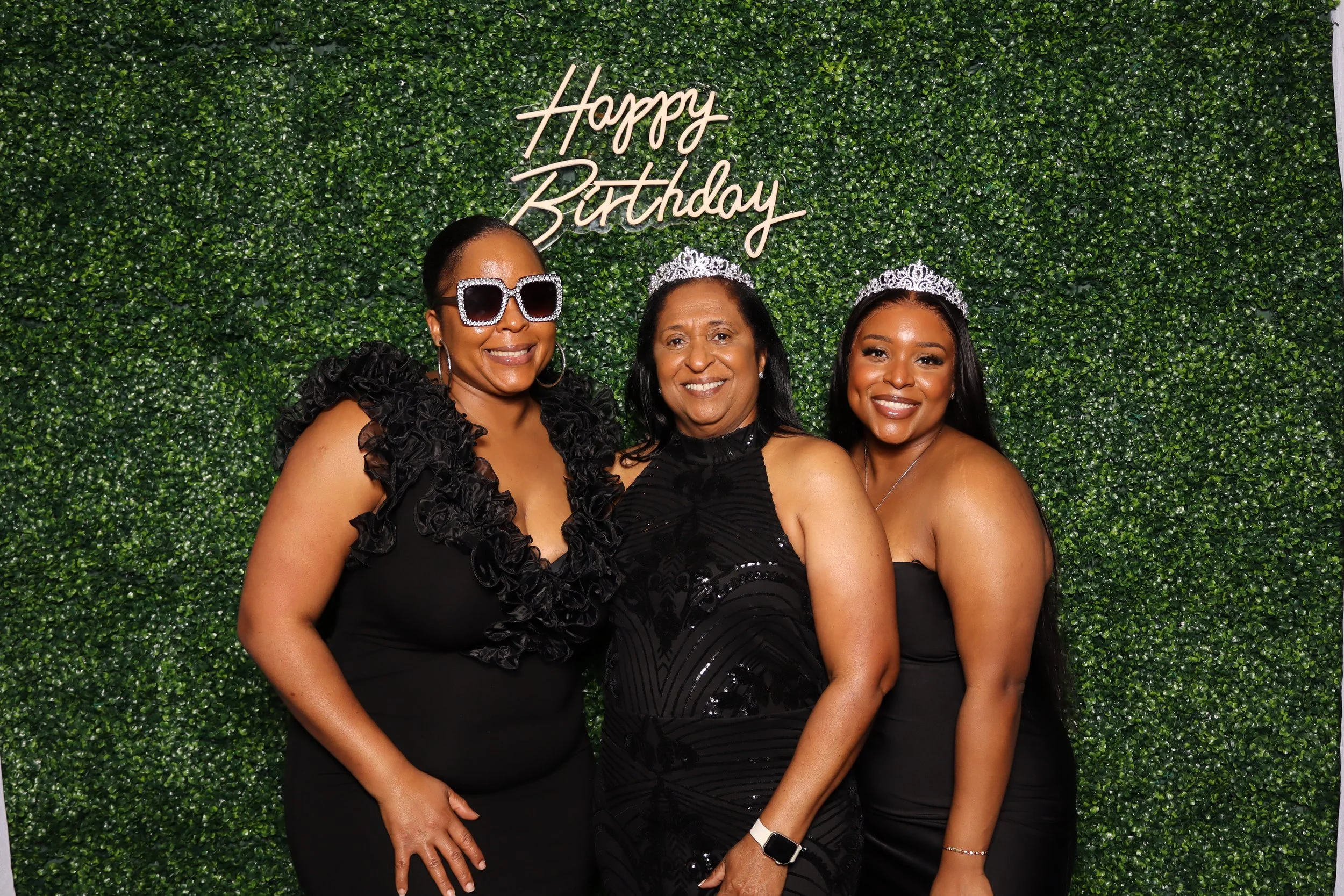 Birthday photo booth rental at Jacaranda Golf Club in Plantation, FL with green hedge wall and “Happy Birthday” sign