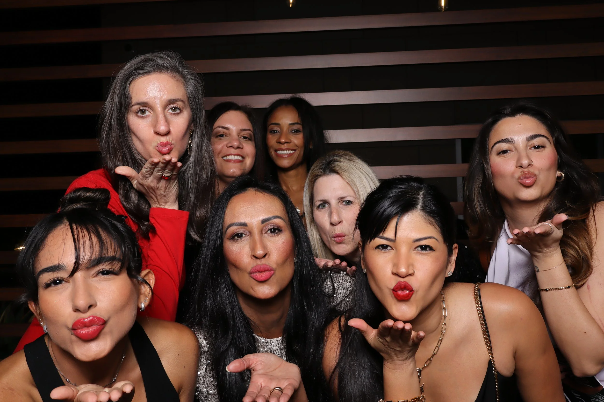 Palm Beach Gardens corporate holiday party photo booth with wooden wall and Santa and elf hats at Life Time Fitness