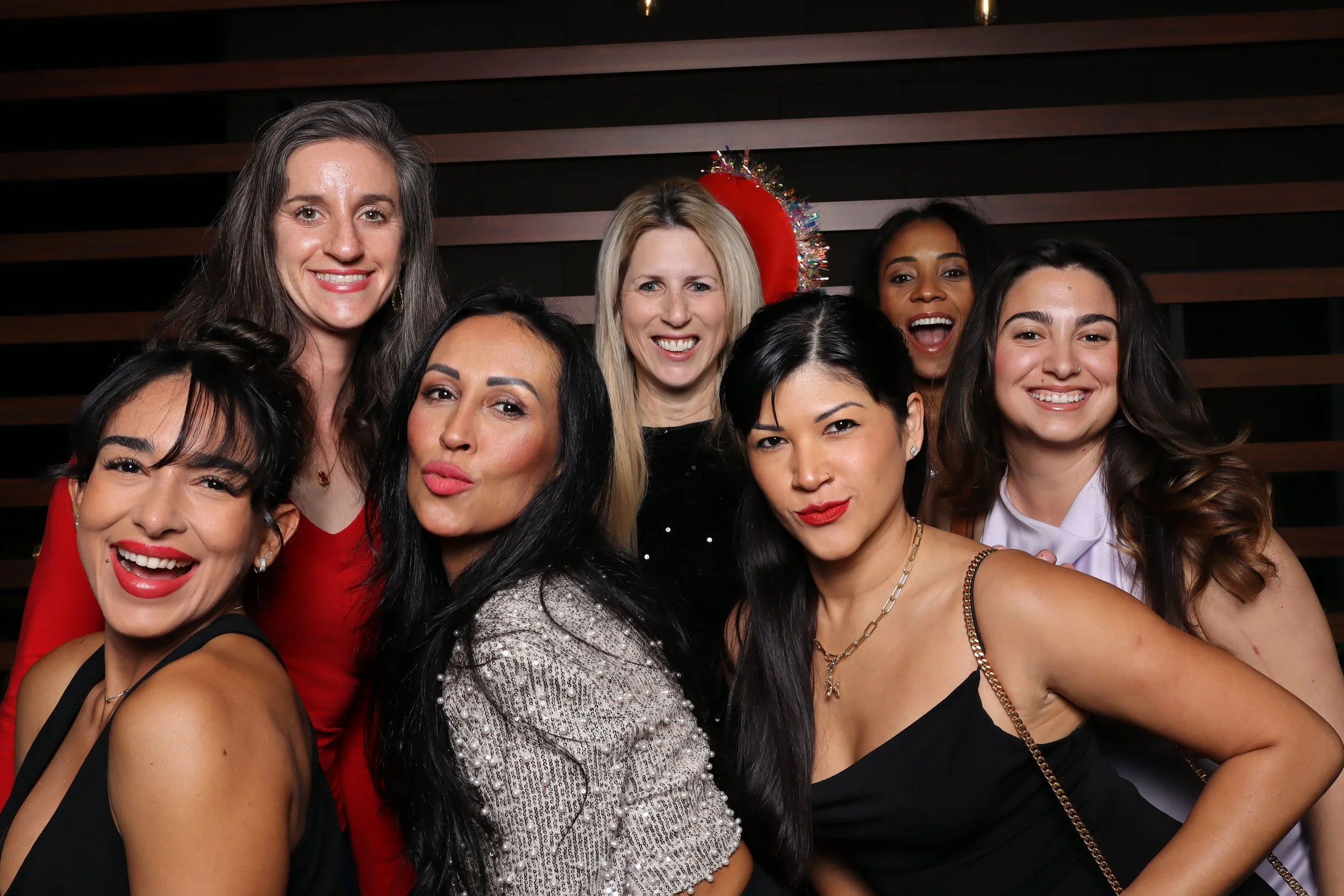 Palm Beach Gardens corporate holiday party photo booth with wooden wall and Santa and elf hats at Life Time Fitness