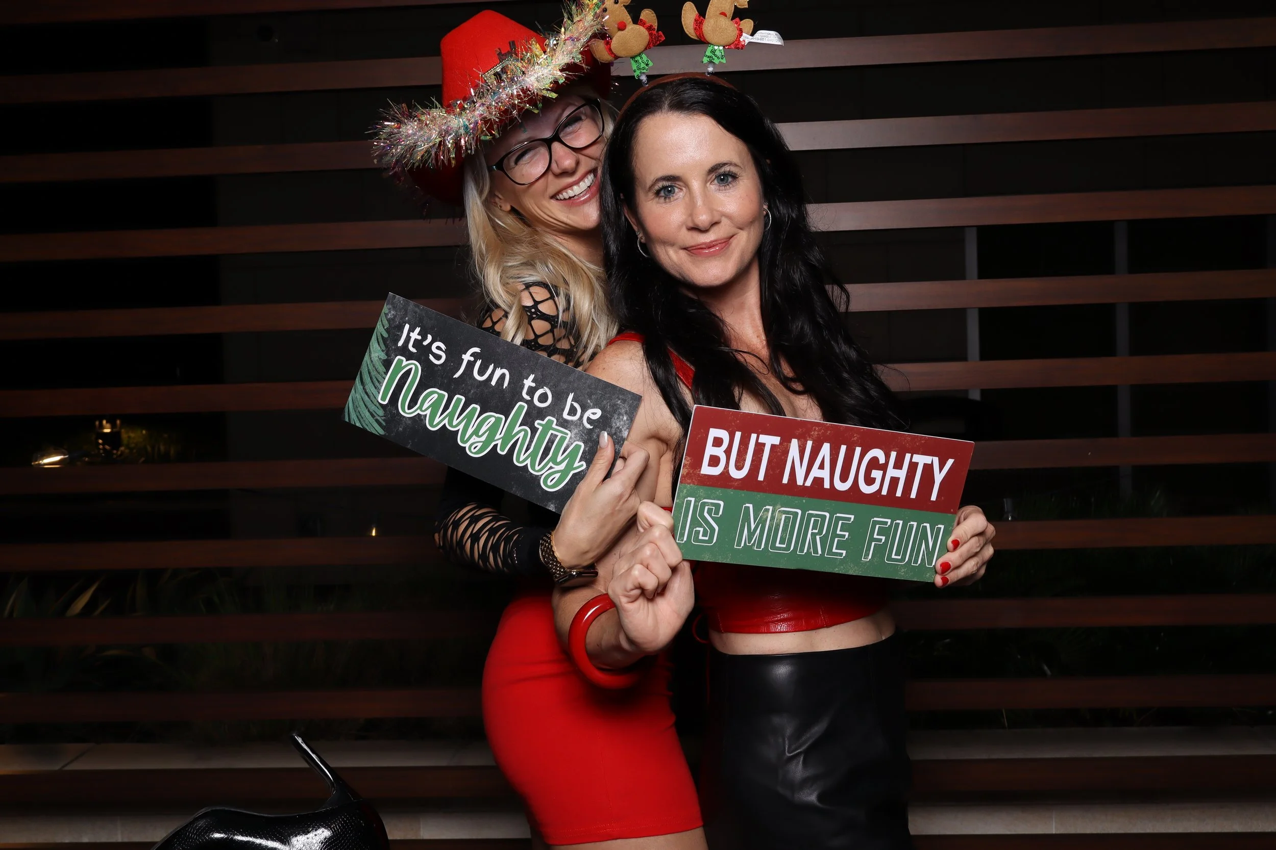 Corporate Christmas party photo booth rental at Life Time Fitness in Palm Beach Gardens with wooden wall and holiday accessories