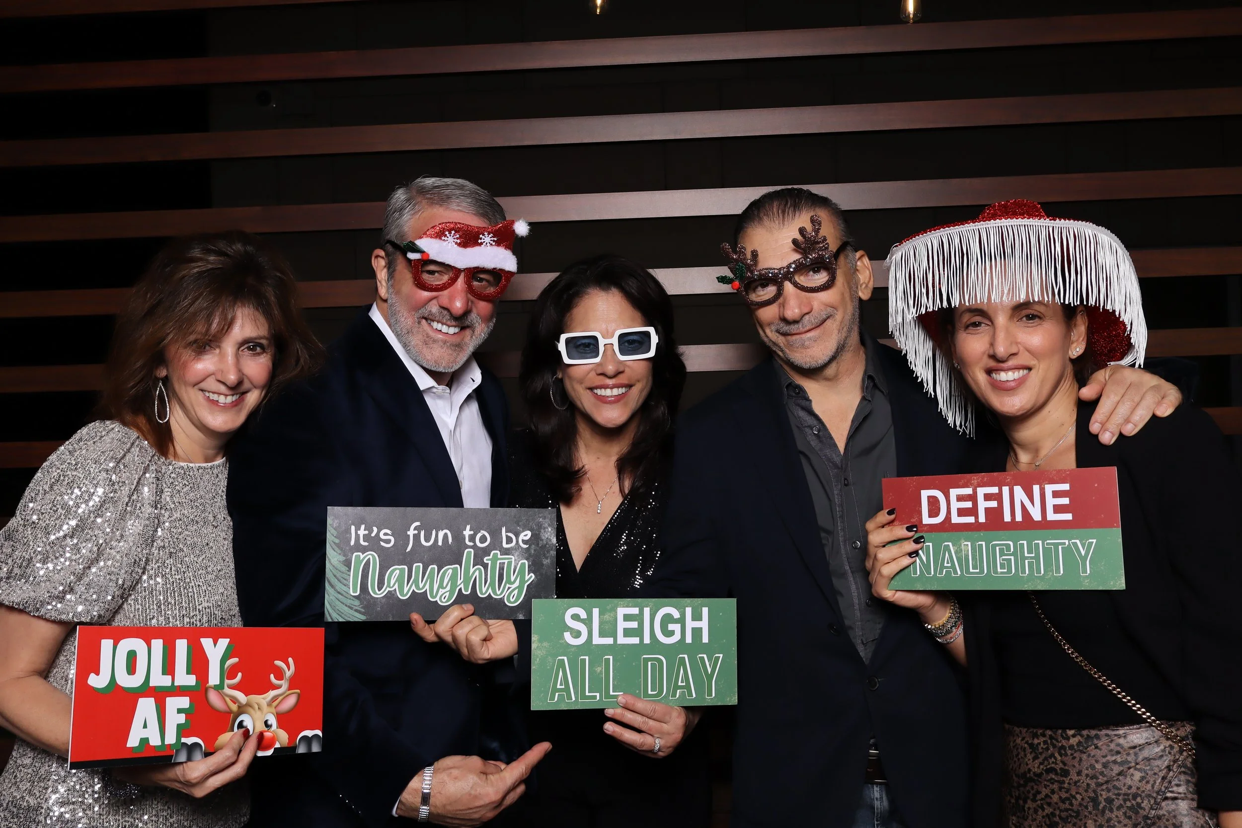 Palm Beach Gardens corporate holiday party photo booth with wooden wall and Santa and elf hats at Life Time Fitness
